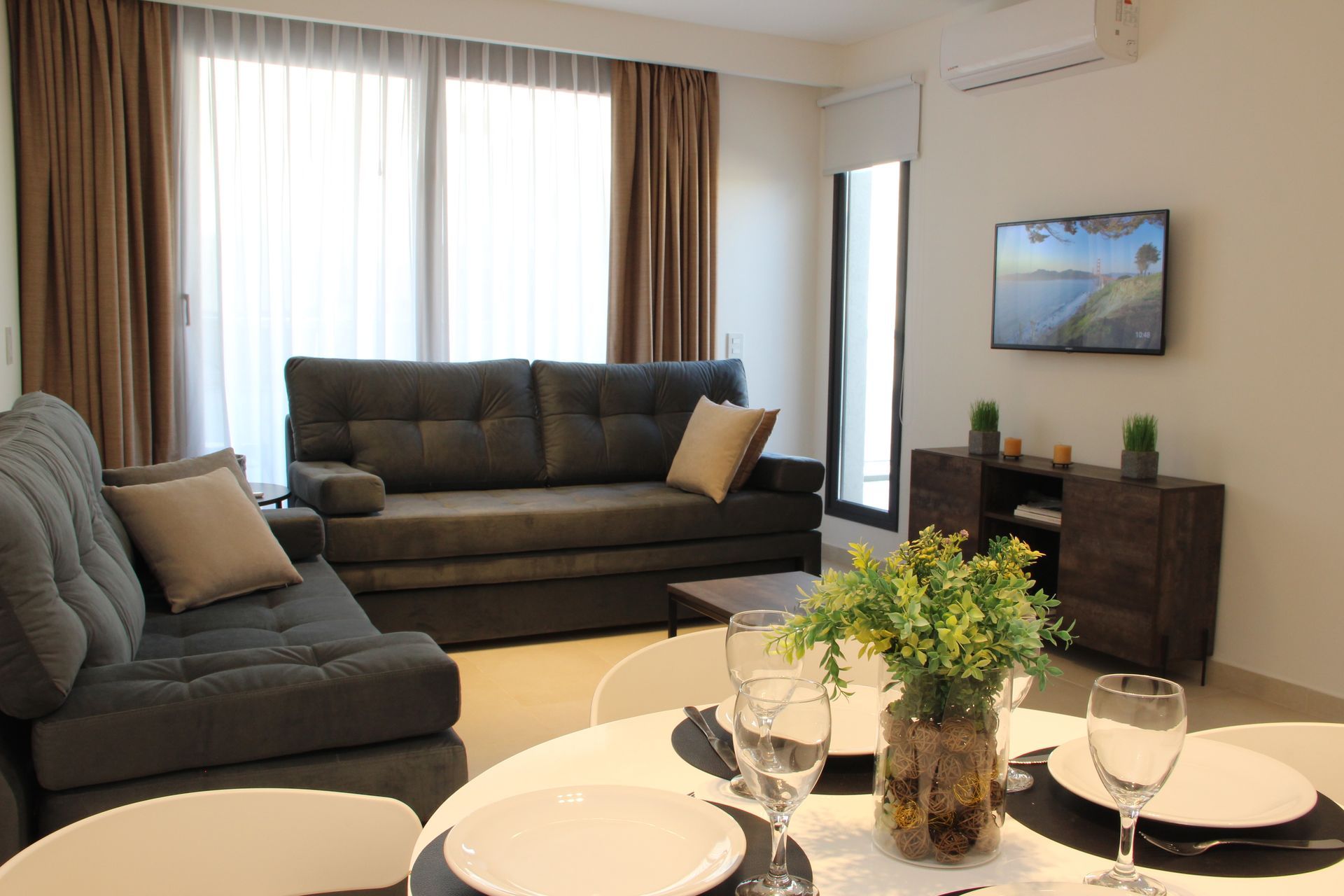 Una sala de estar con un sofá y una mesa con platos y copas de vino.