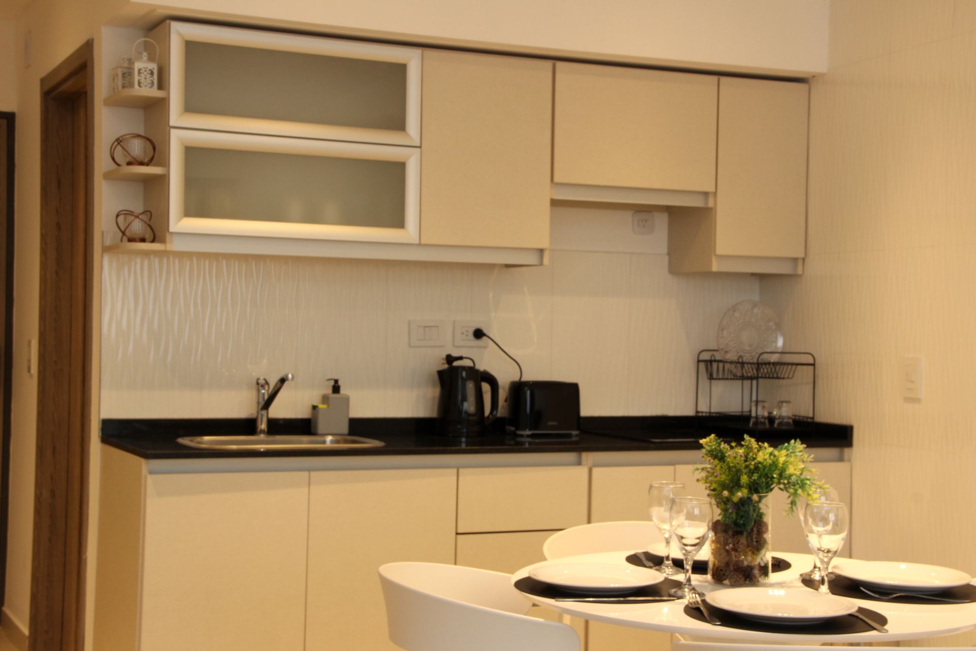 Una cocina con una mesa, sillas y platos encima.