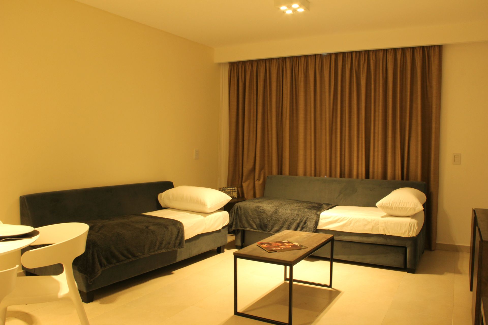 Una sala de estar con dos camas y una mesa de café.