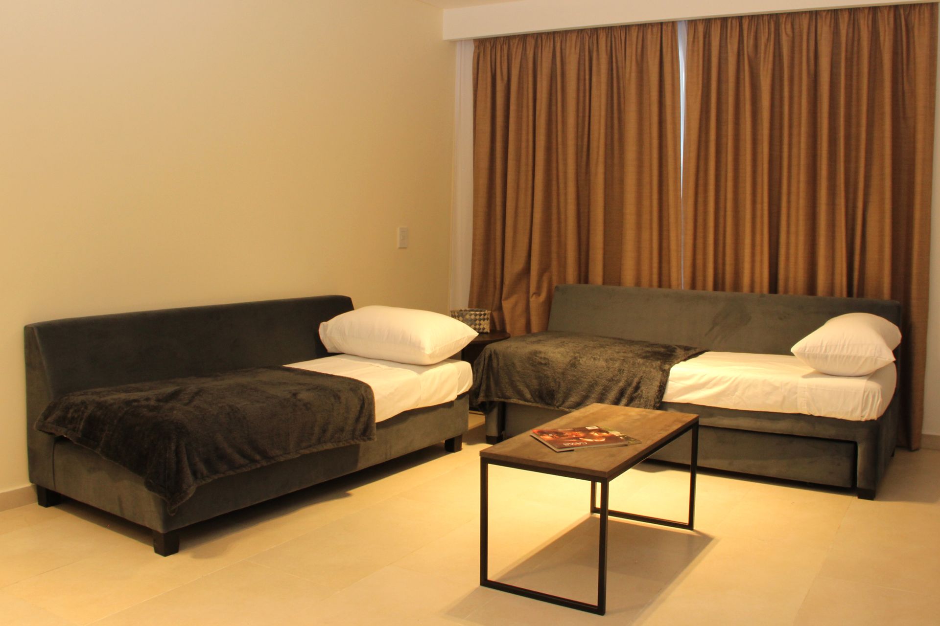 Una sala de estar con dos camas y una mesa de café.