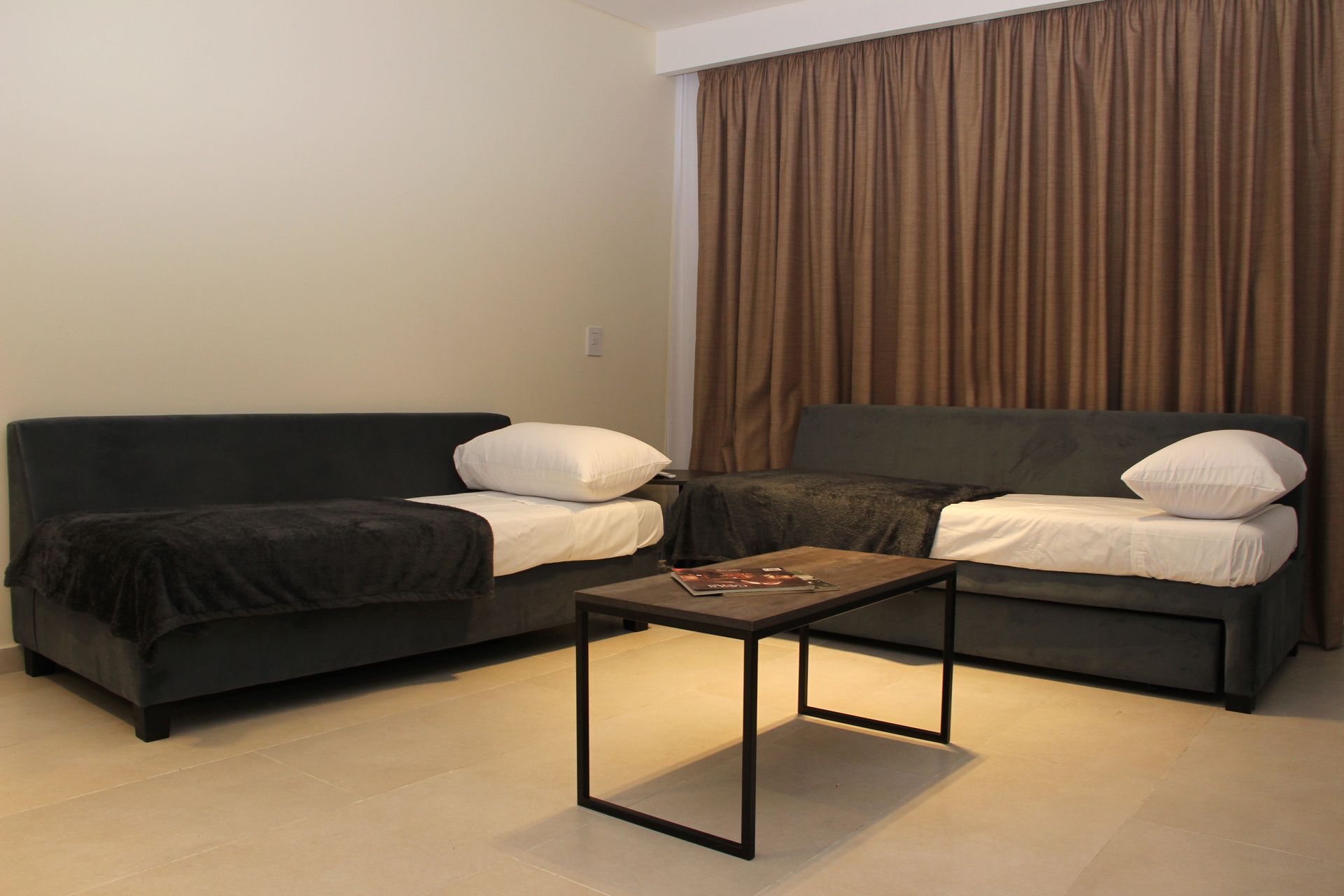 Una sala de estar con dos camas y una mesa de café.