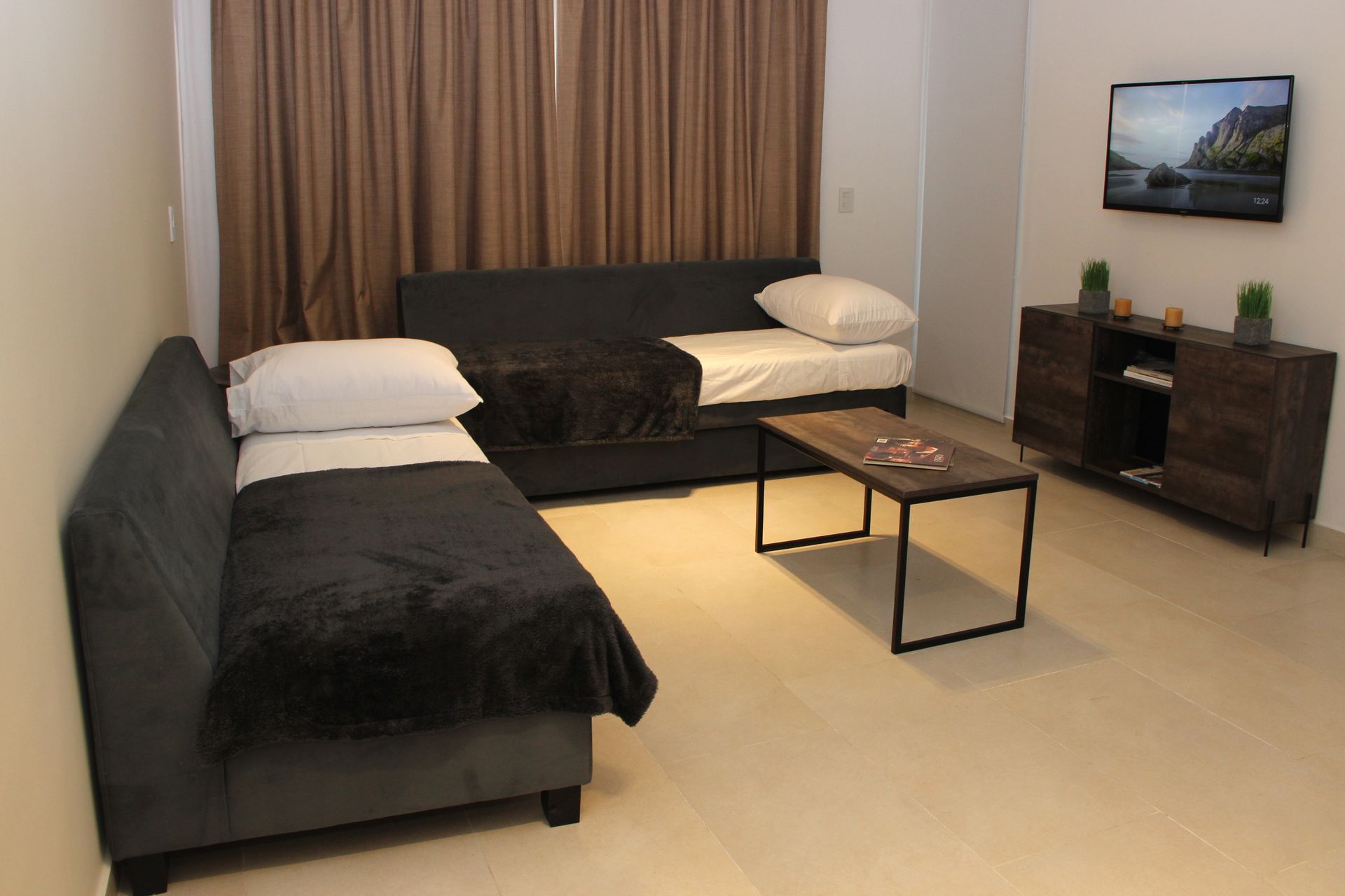 Una sala de estar con un sofá y dos camas.