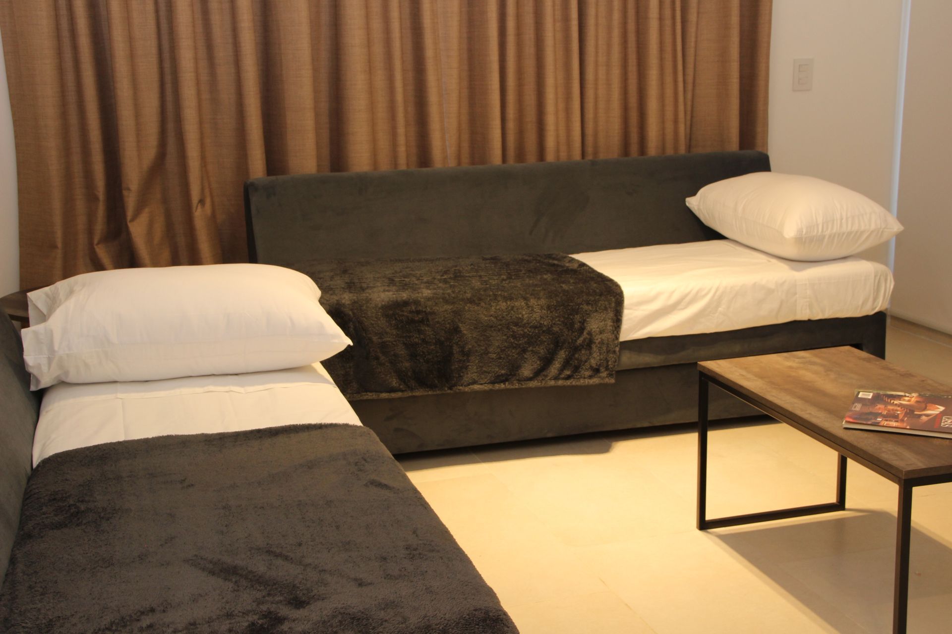 Una sala de estar con dos camas y un sofá