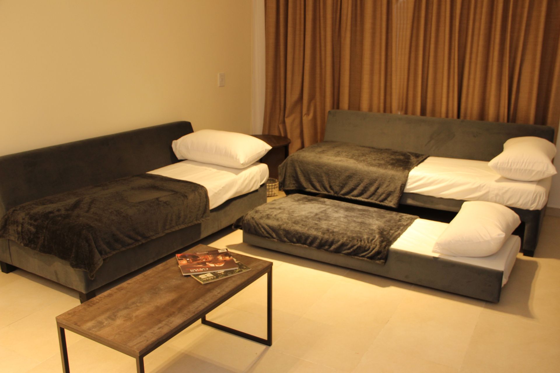 Una sala de estar con dos camas y una mesa de café.