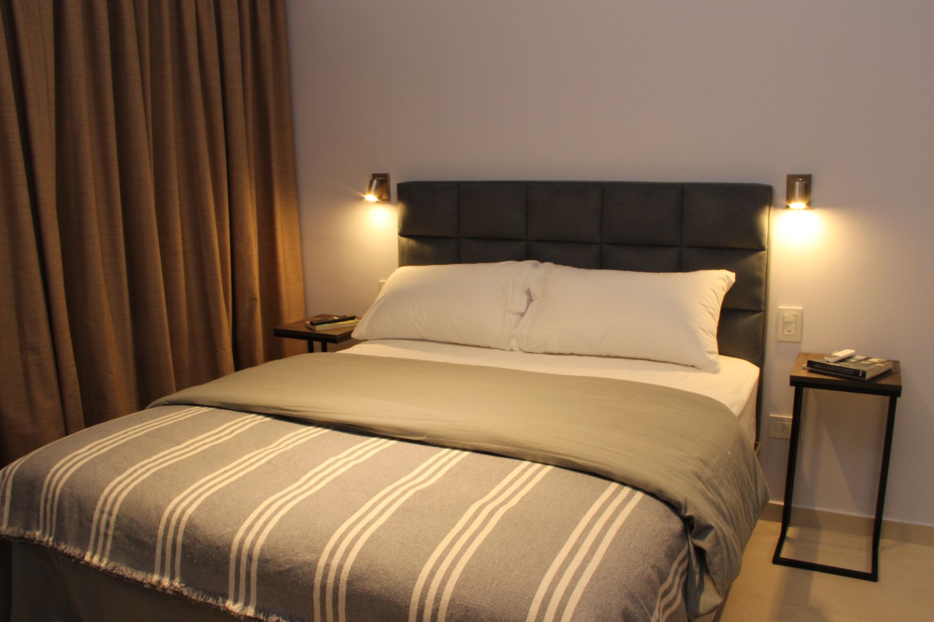 Un dormitorio con una cama y dos mesitas de noche.