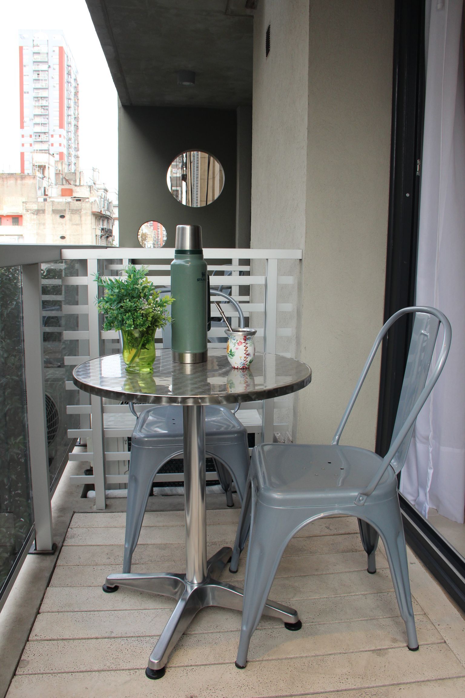 Hay una mesa y sillas en el balcón.