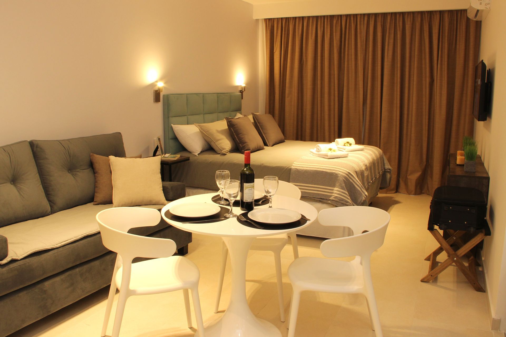 Una sala de estar con un sofá, una mesa y sillas y una cama.