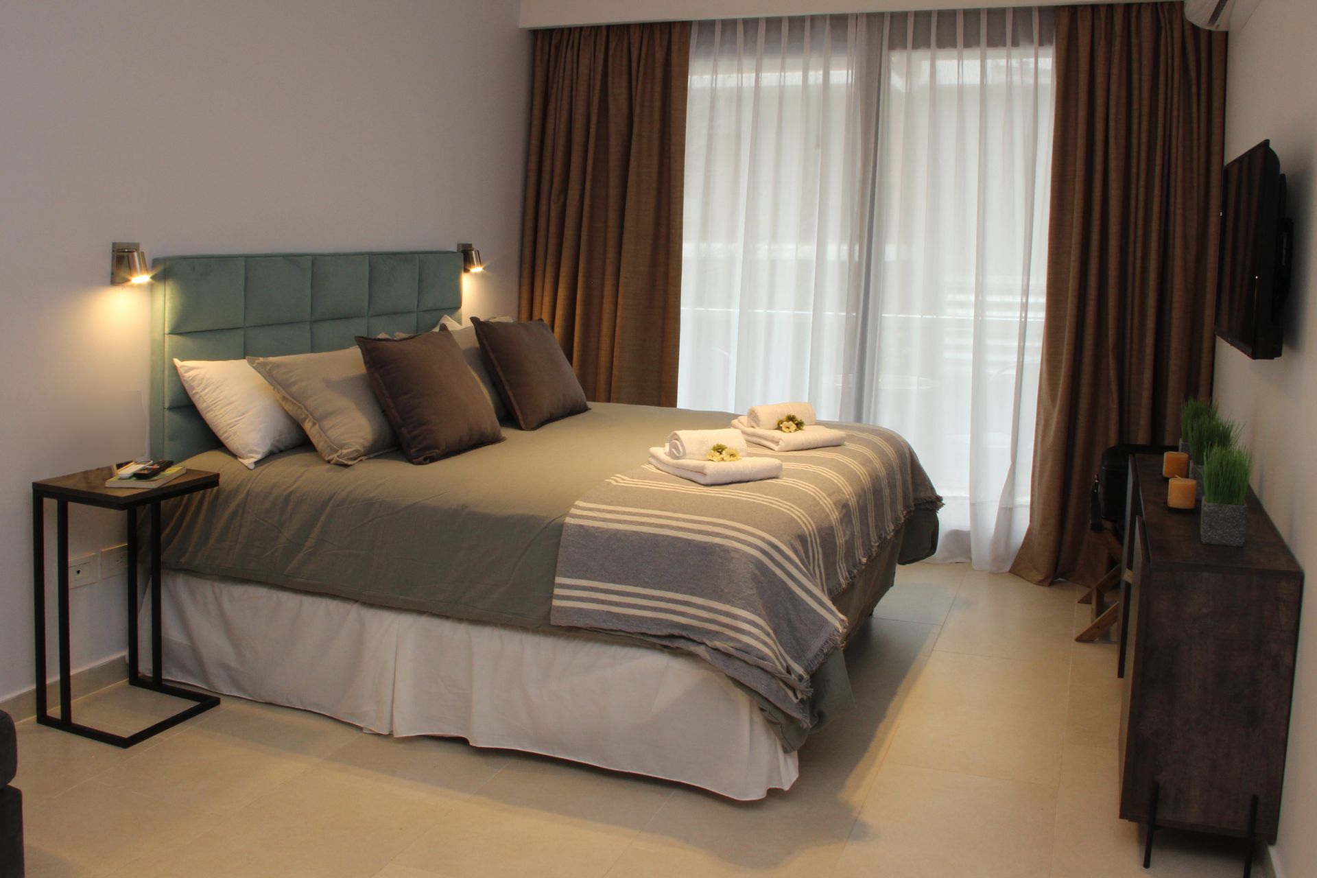 Una habitación de hotel con una cama grande y un televisor.