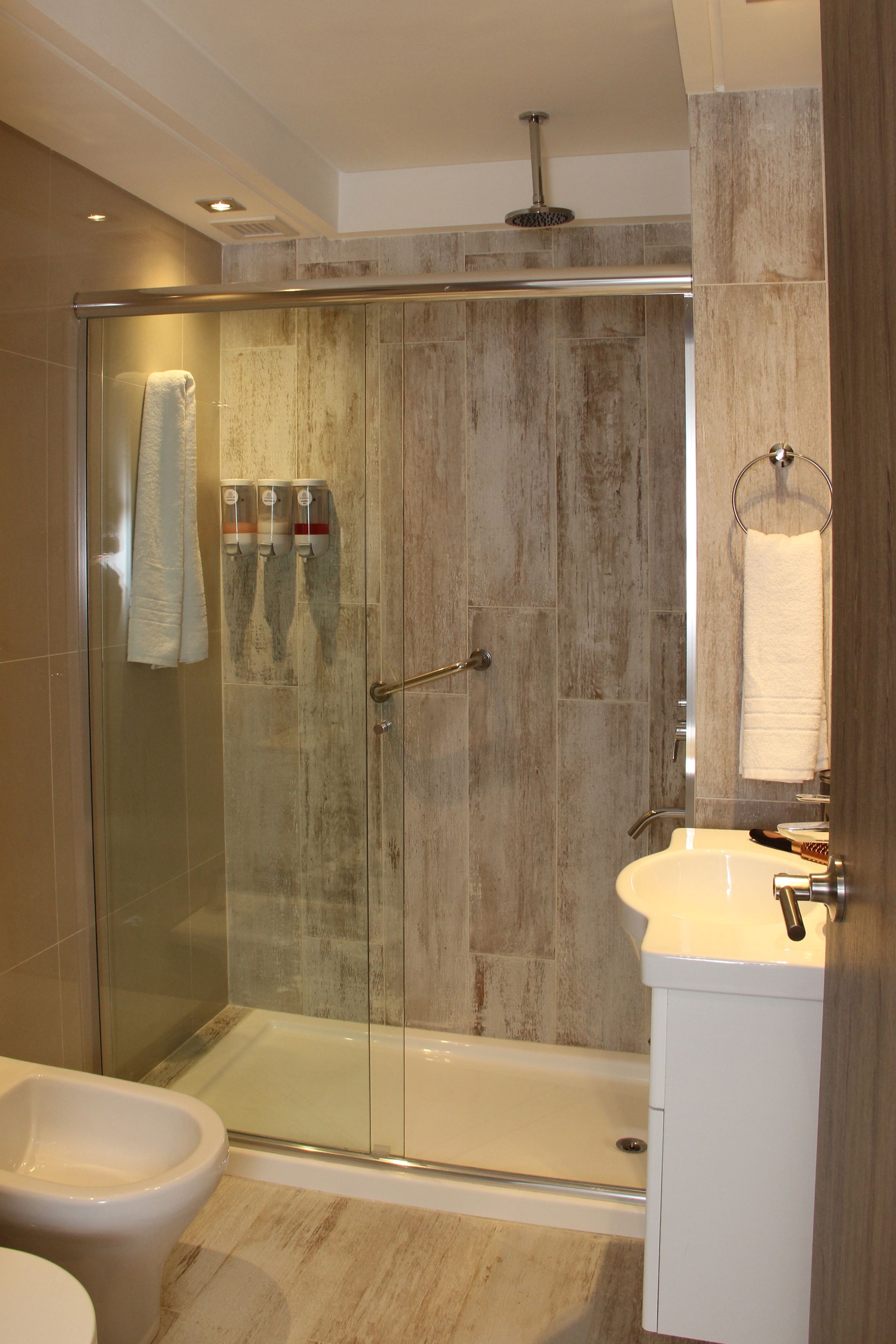 Un baño con inodoro, lavabo y ducha.