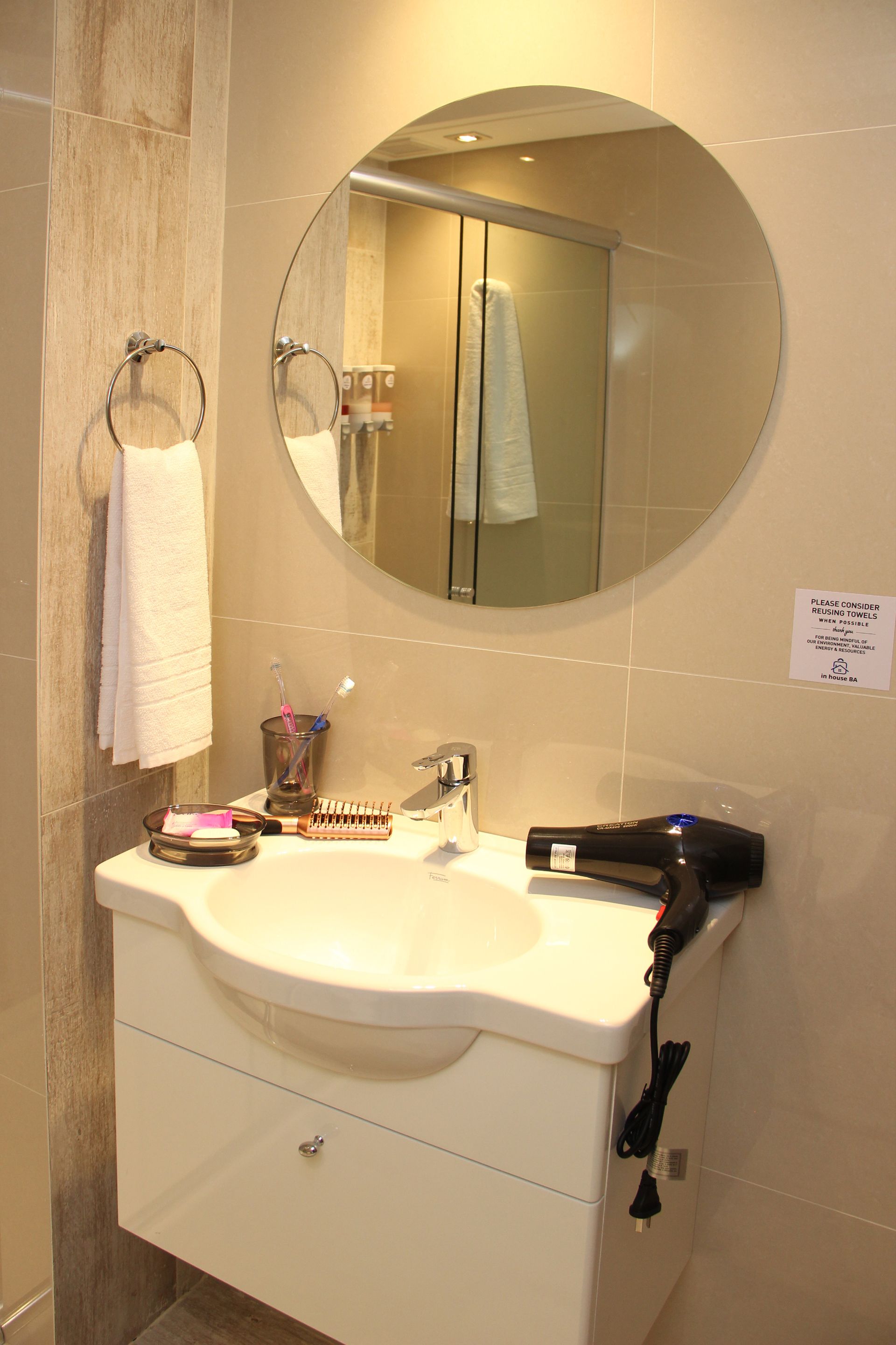 Un baño con lavabo, espejo y secador de pelo.