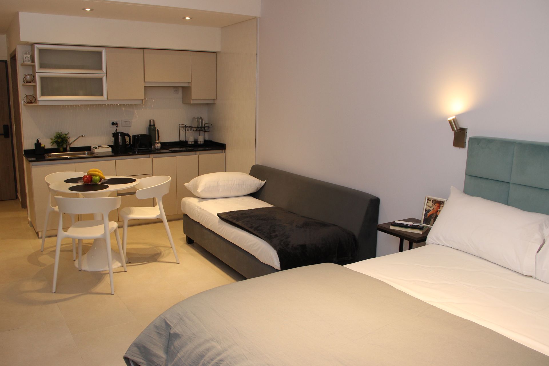 Un dormitorio con cama, sofá, mesa y sillas.