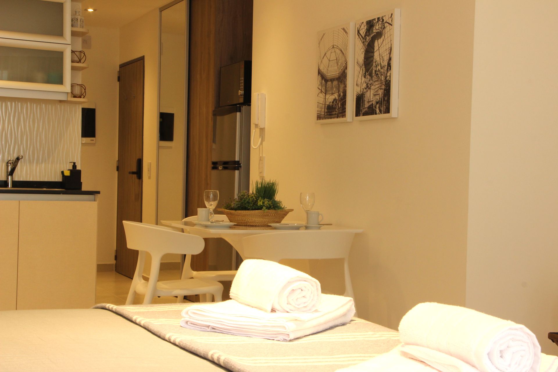 Un dormitorio con una mesa y sillas y toallas en la cama.