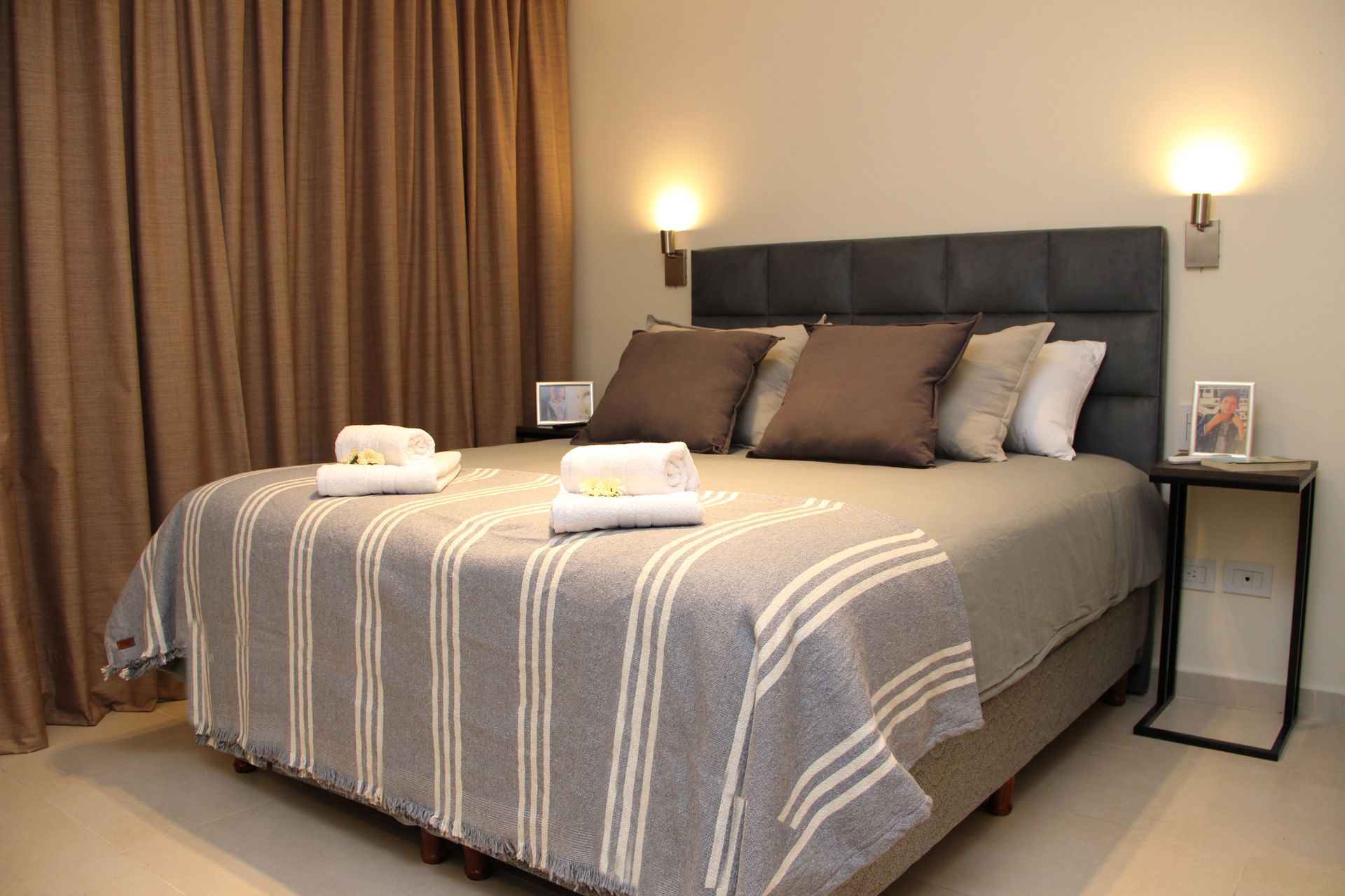 Una cama con una manta a rayas y almohadas en un dormitorio.