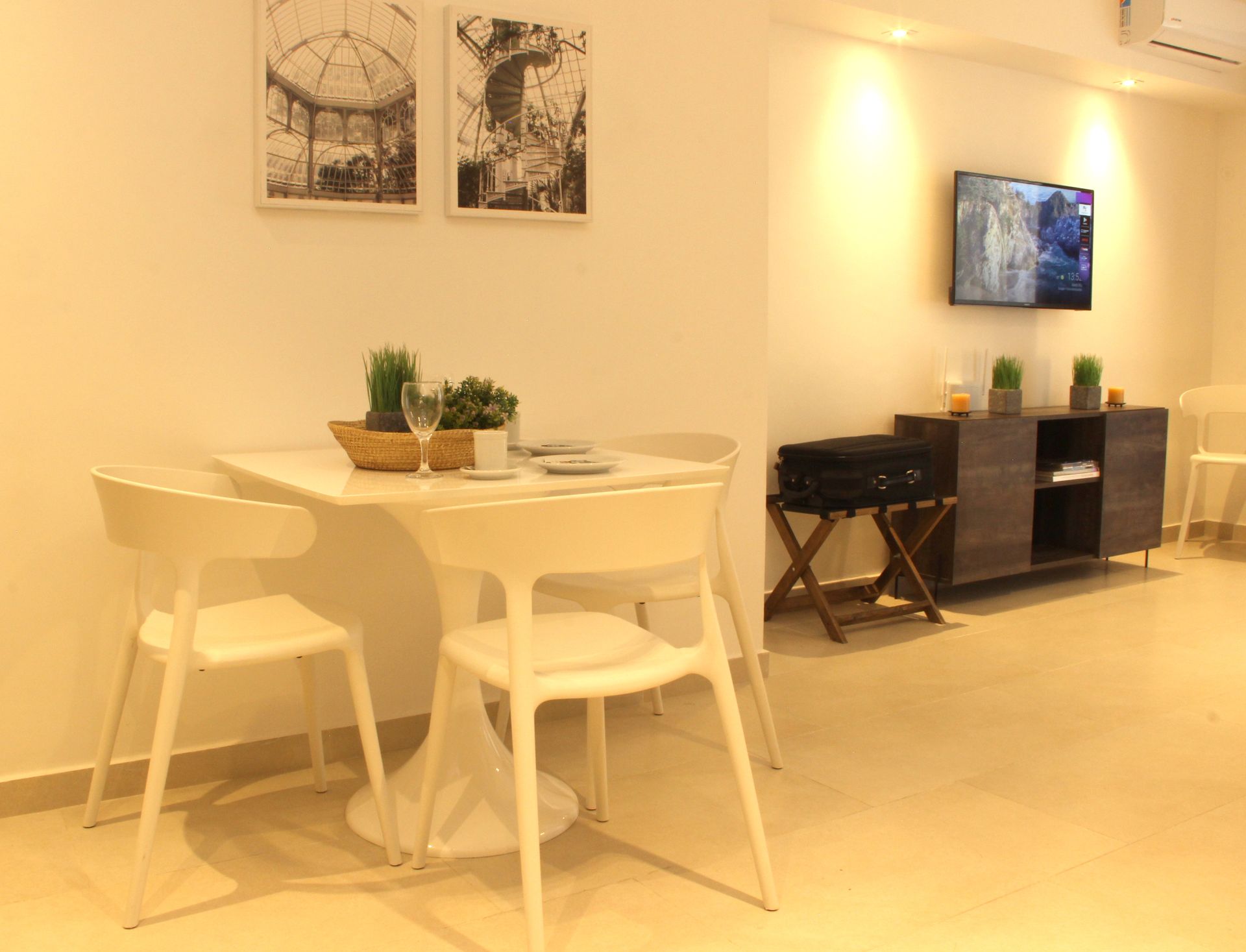 Una sala de estar con una mesa y sillas y un televisor.