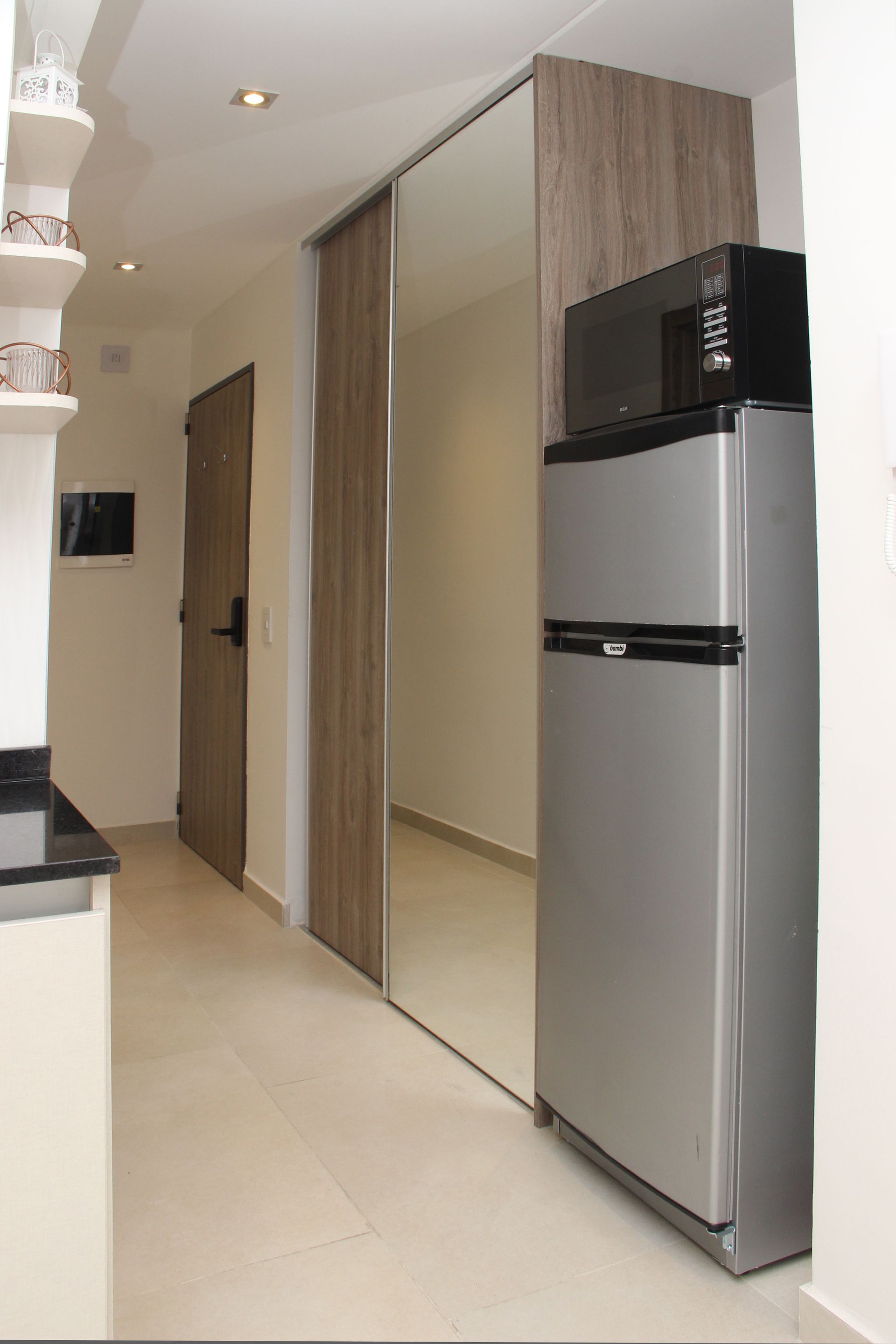 Una cocina con refrigerador de acero inoxidable y microondas.