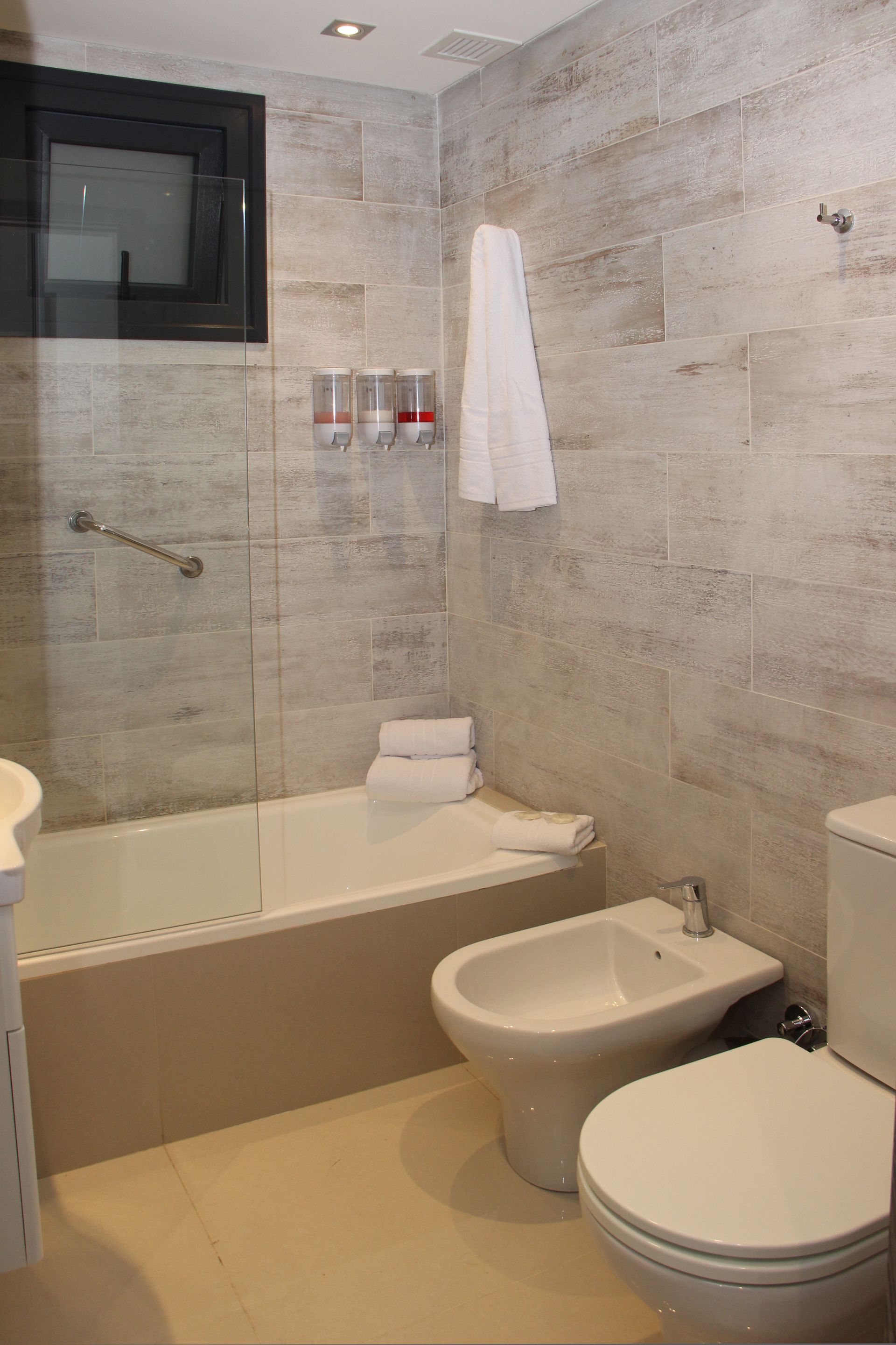 Un baño con inodoro, bidet, bañera y ducha.