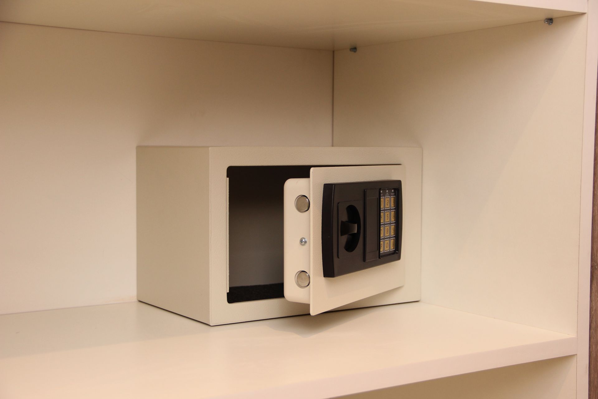 Una caja fuerte está sobre un estante con la puerta abierta.