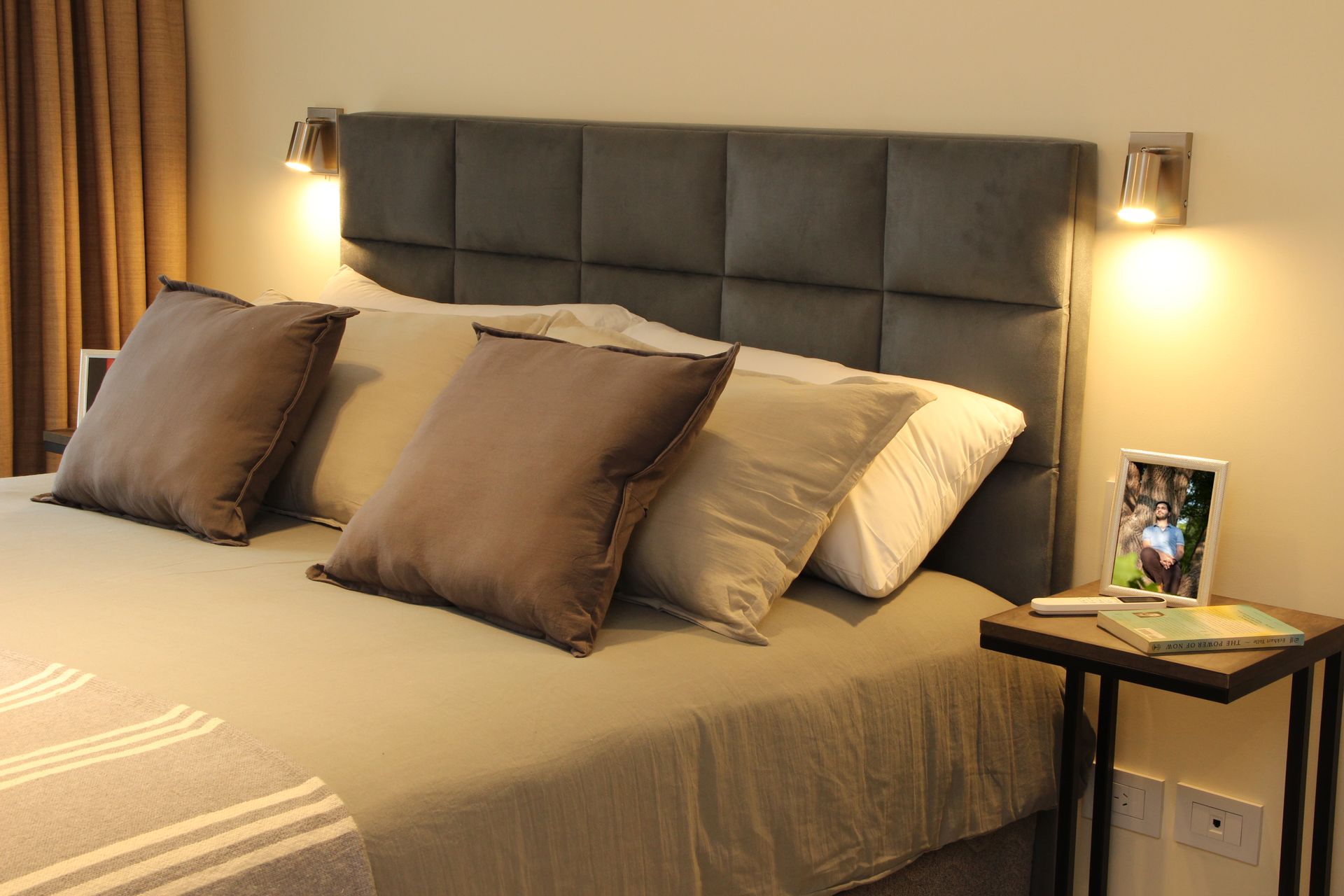 Una cama con cabecero y almohadas en un dormitorio.