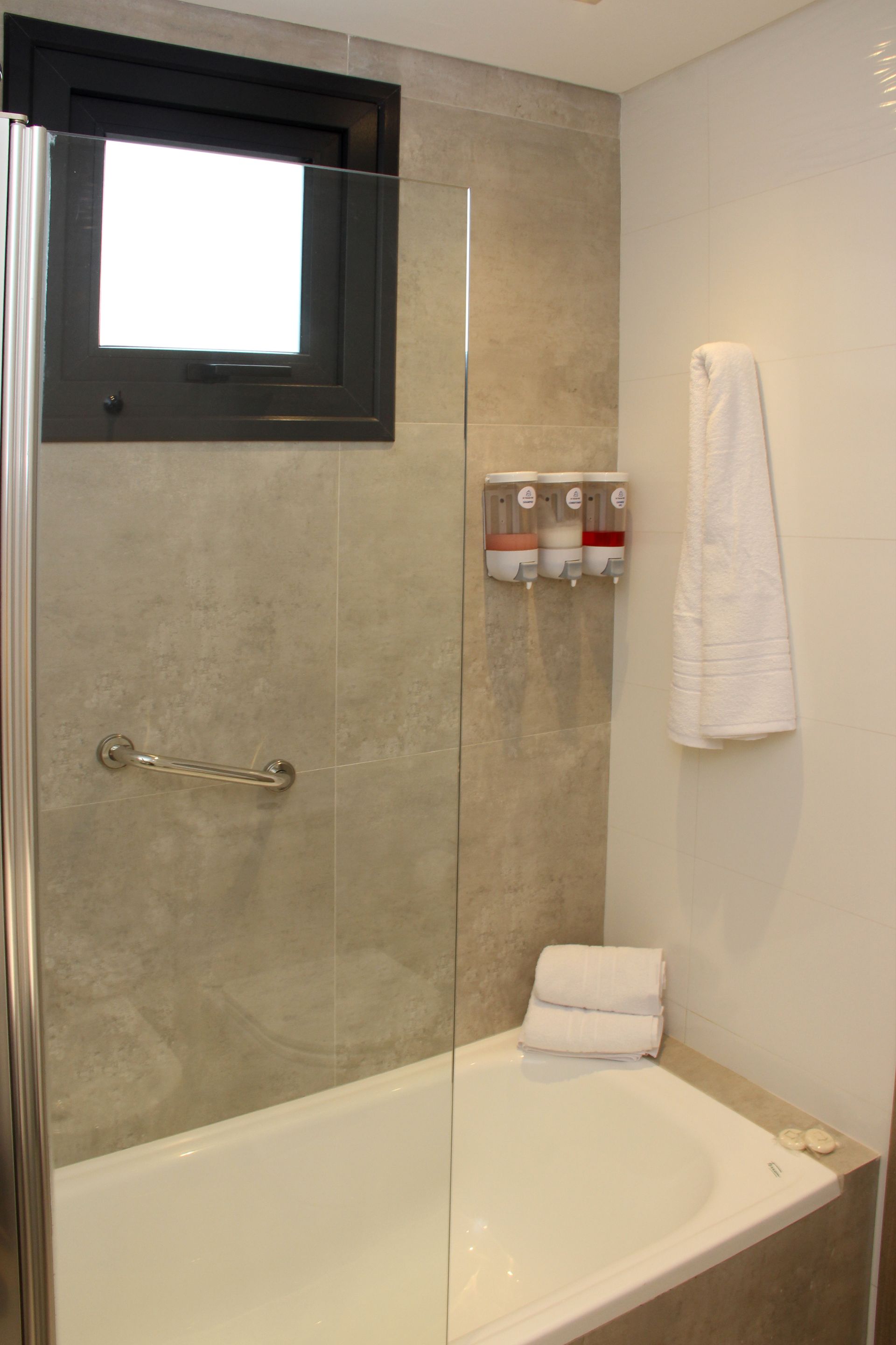 Un baño con bañera, ducha y ventana.