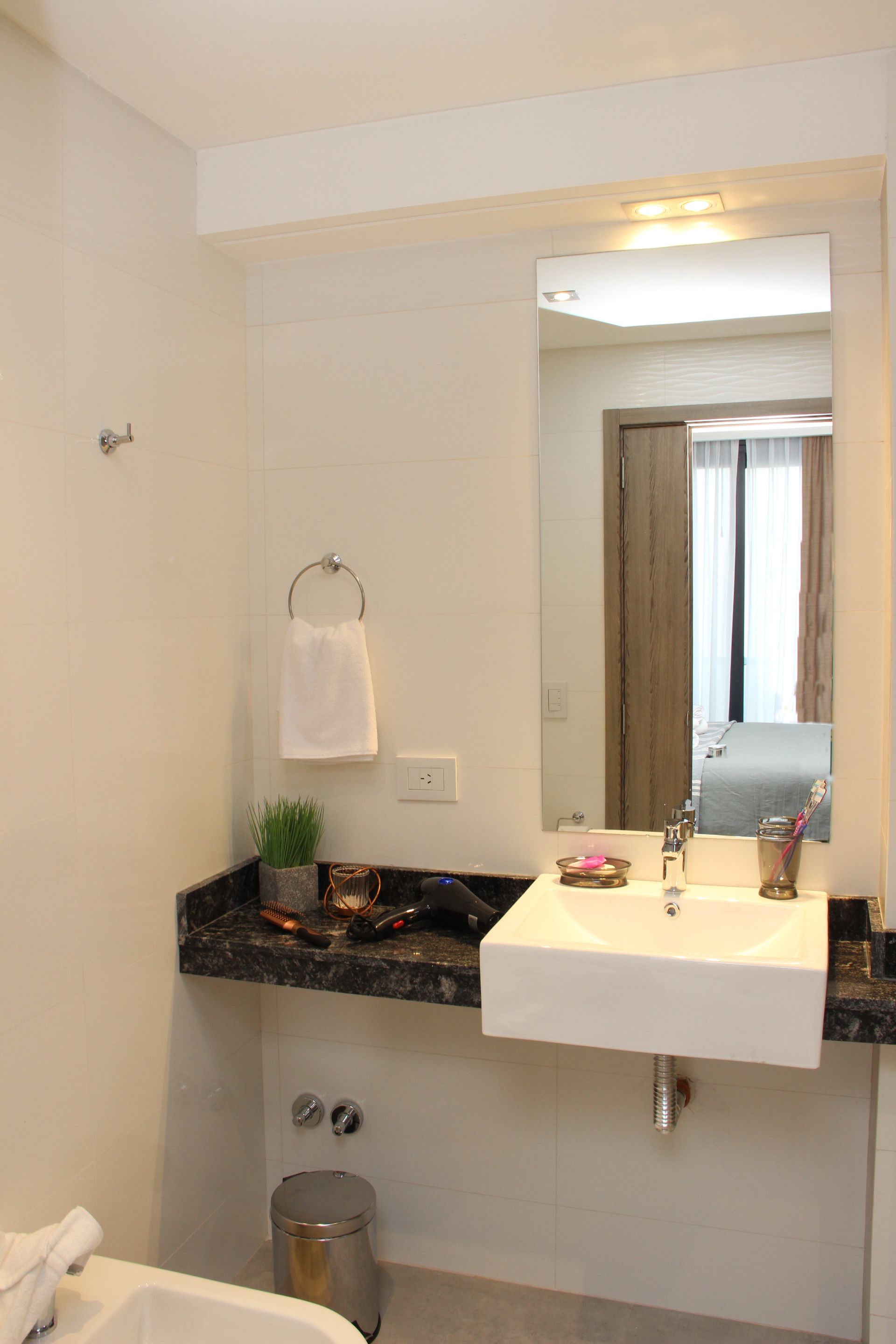 Un baño con lavabo, inodoro y espejo.