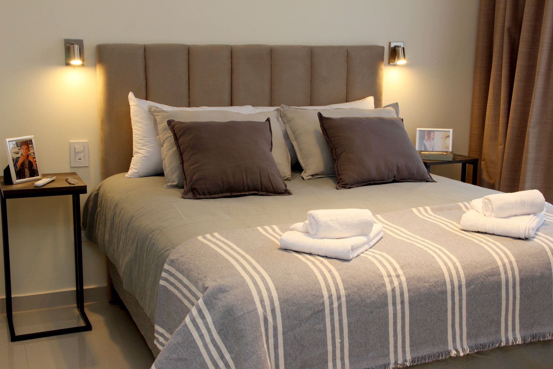 Una cama con una manta a rayas y almohadas en un dormitorio.