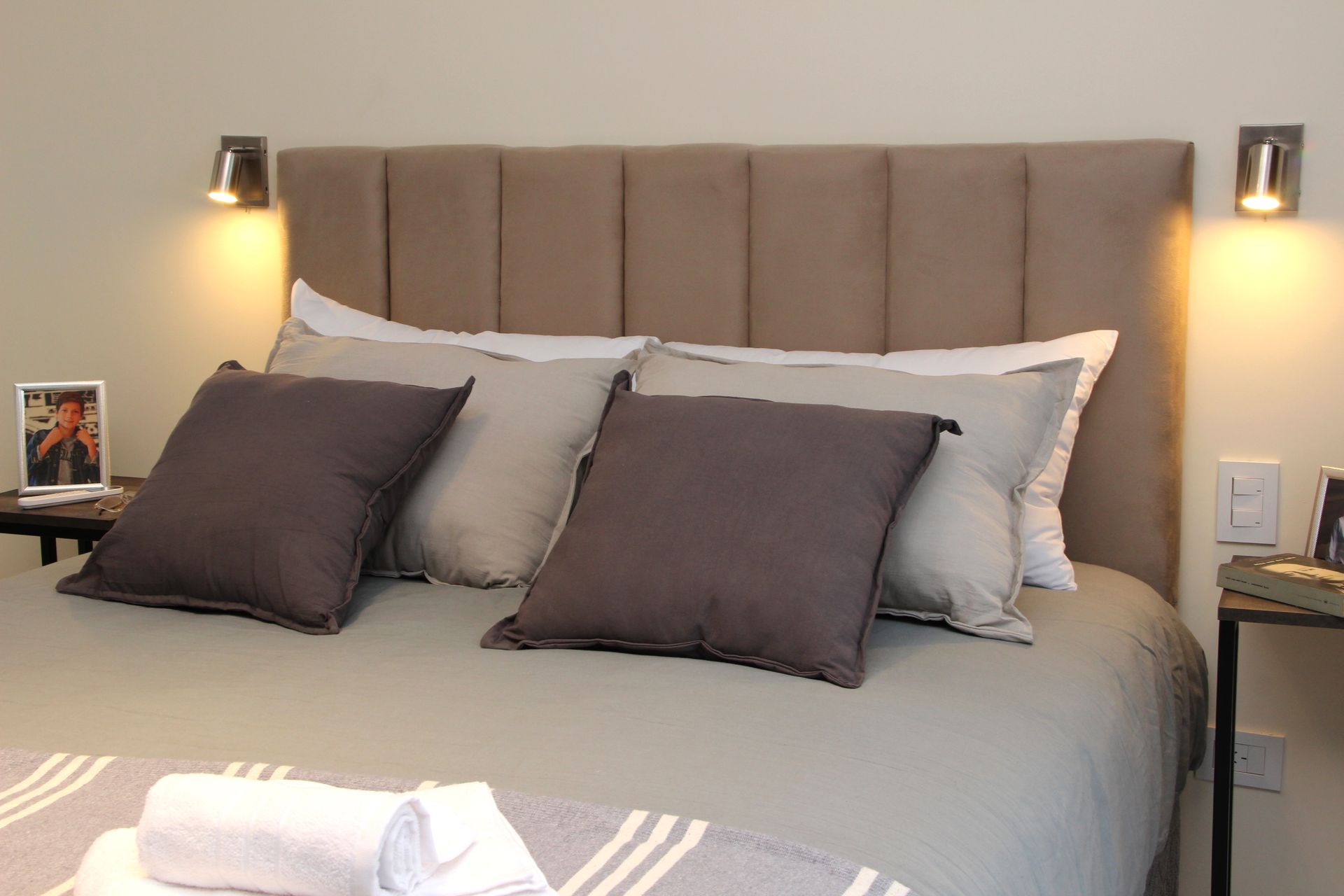 Una cama con cabecero y almohadas.