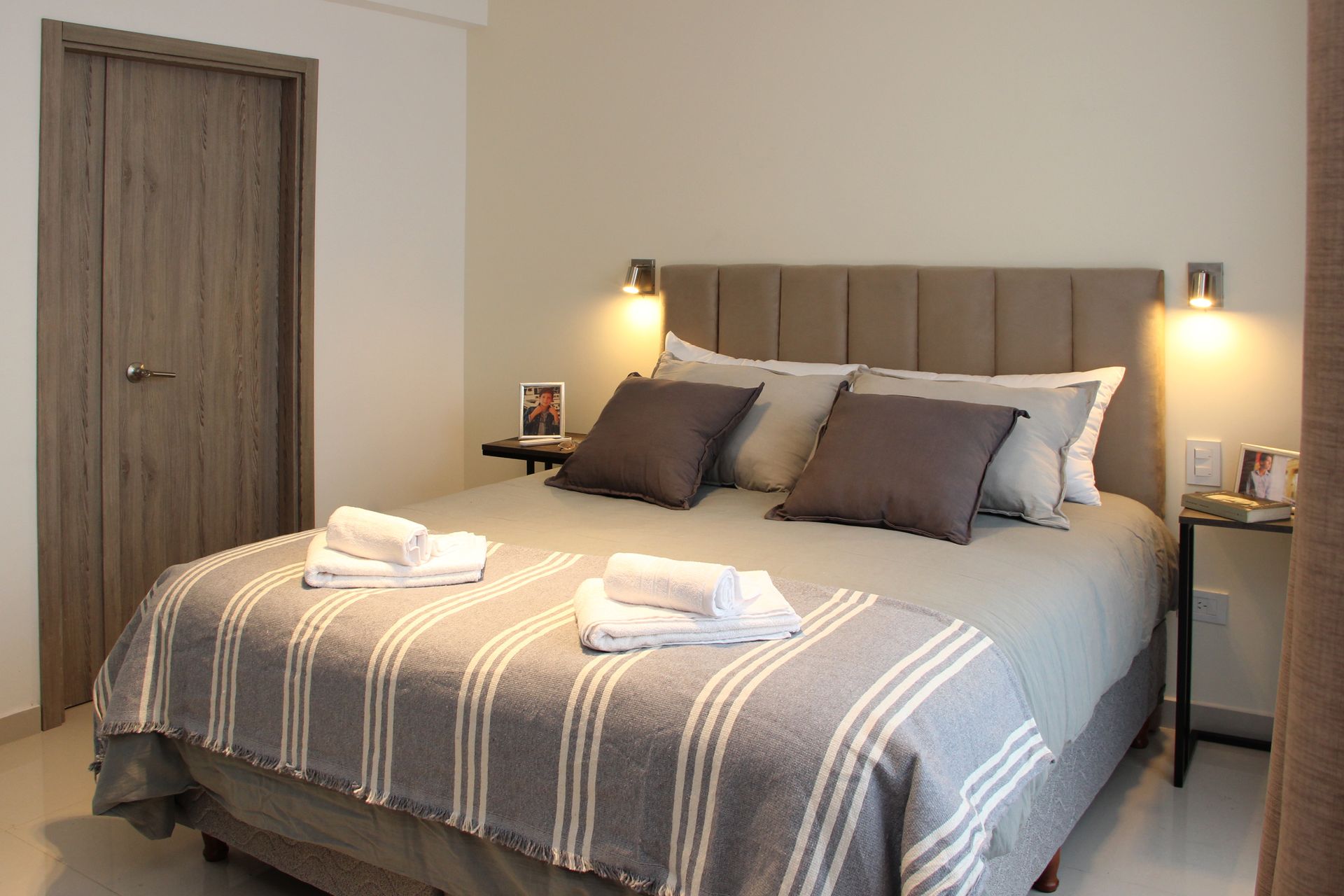 Una cama con una manta a rayas y almohadas en un dormitorio.