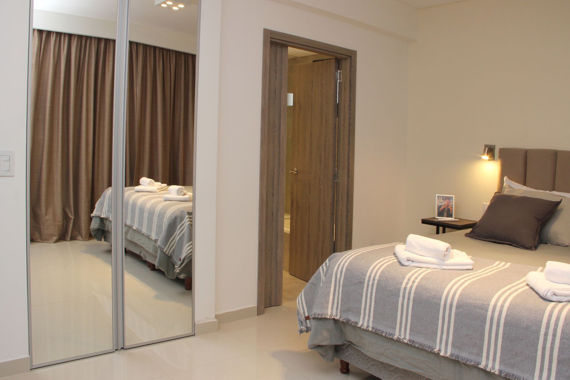 Un dormitorio con cama, armario y espejo.