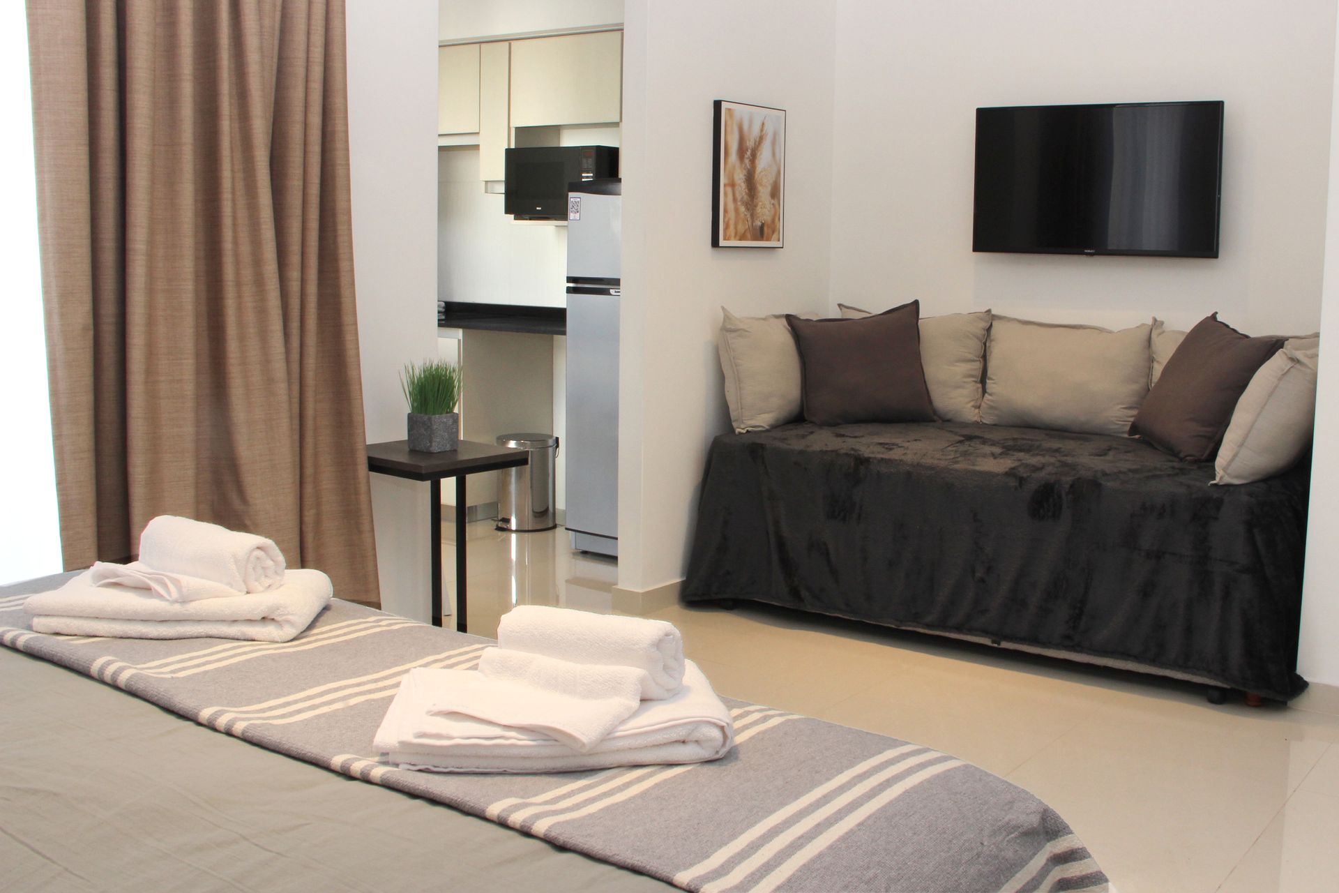 Un dormitorio con una cama, un sofá y una televisión.