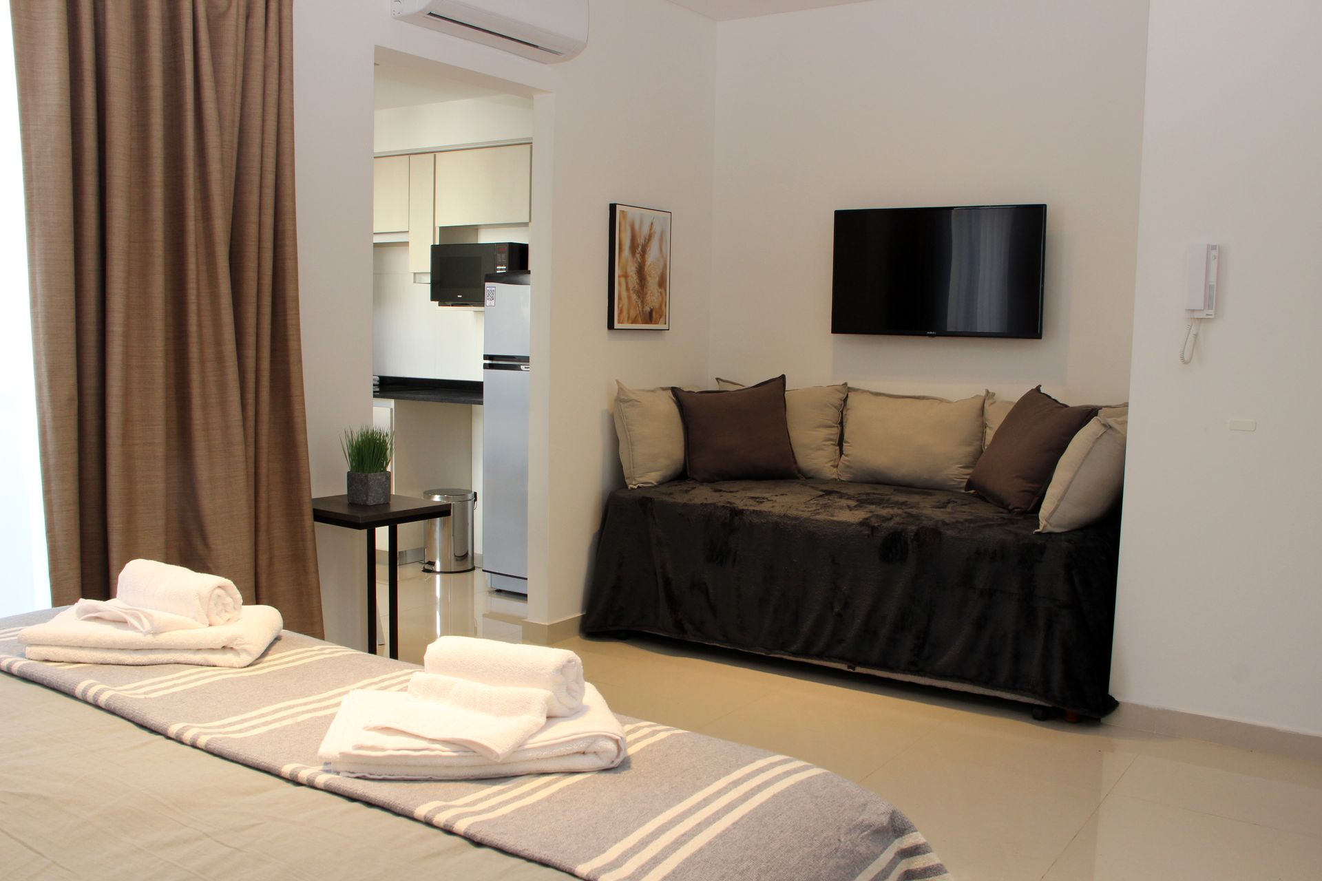 Un dormitorio con un sofá y un televisor de pantalla plana.