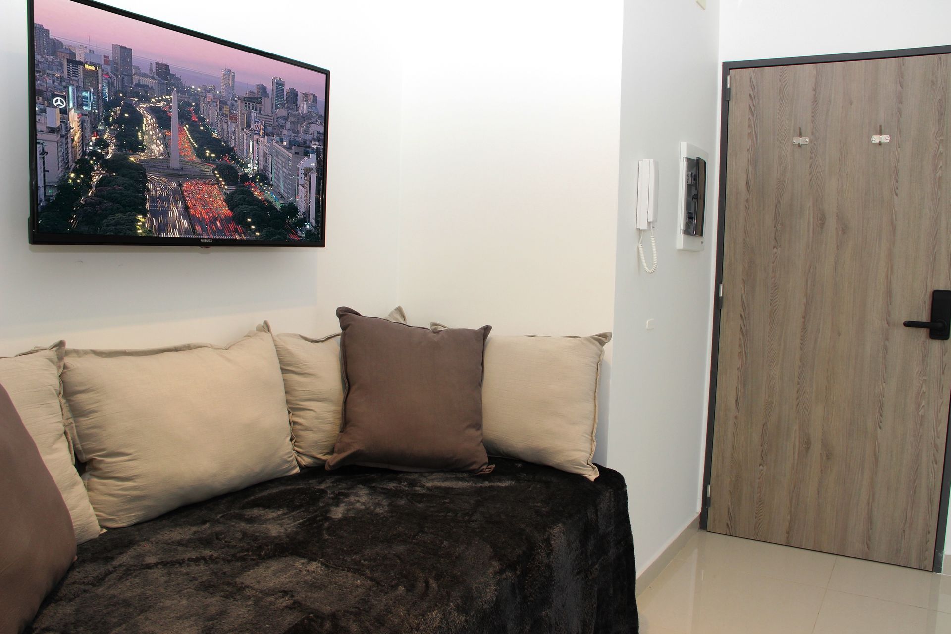 Una sala de estar con un sofá y un televisor en la pared.