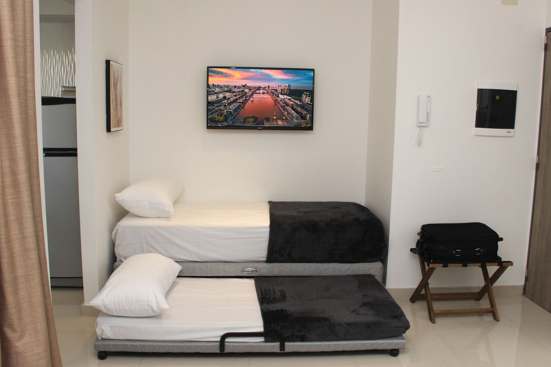 Un dormitorio con dos camas y un televisor de pantalla plana.