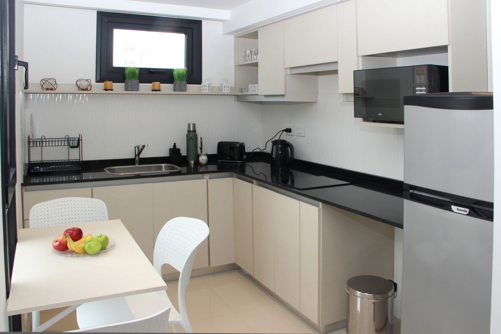 Una cocina con mesa y sillas y un refrigerador.