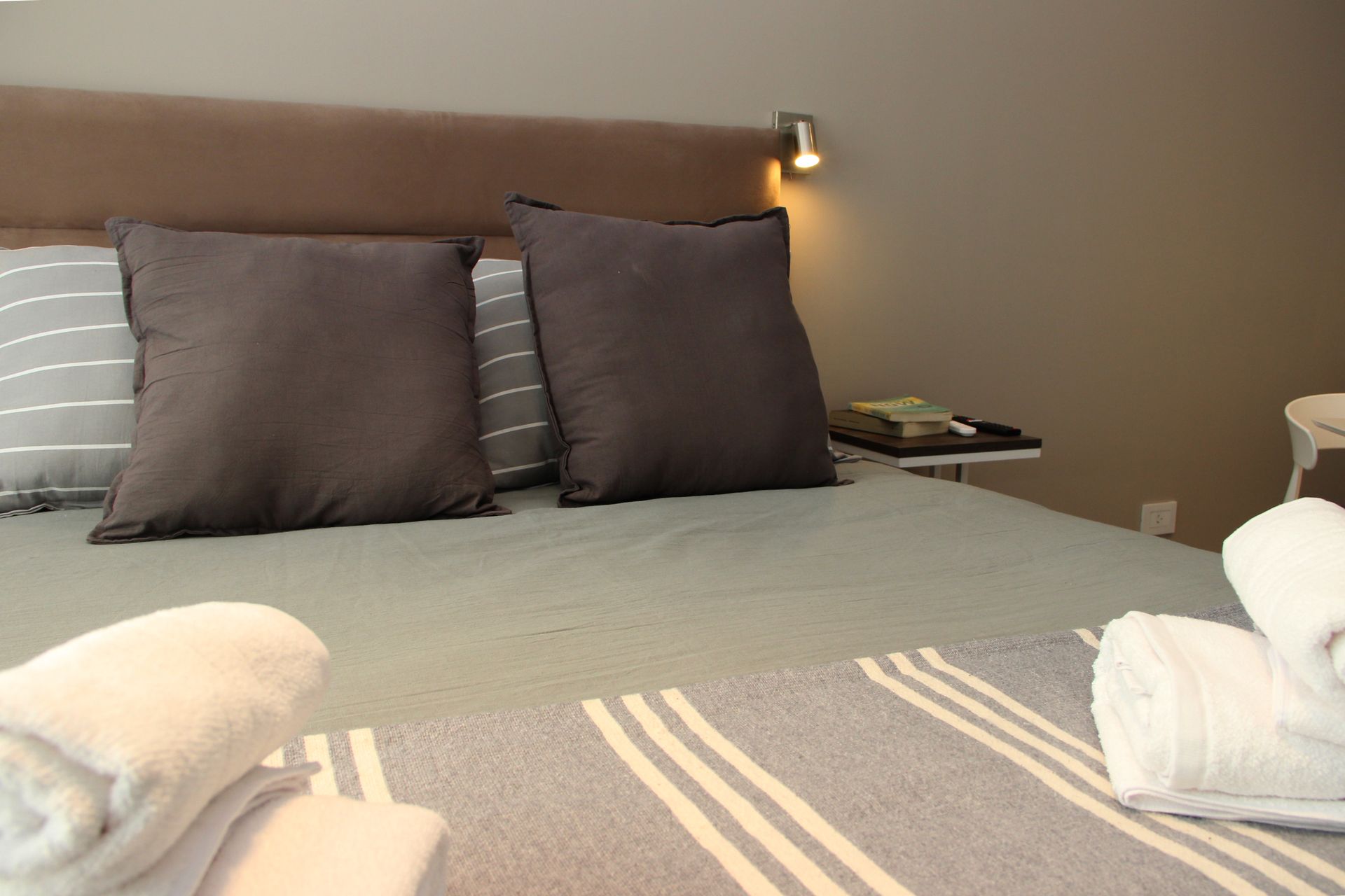 Una cama con almohadas y toallas en una habitación de hotel.