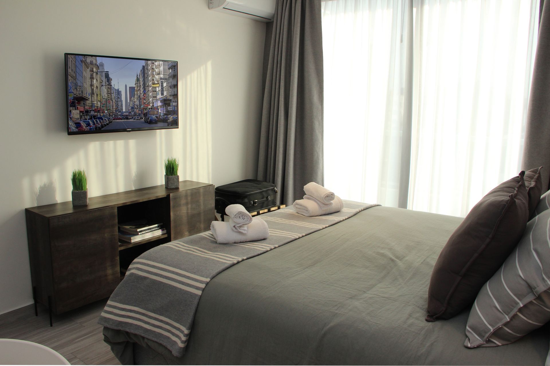 Un dormitorio con una cama grande y un televisor de pantalla plana.