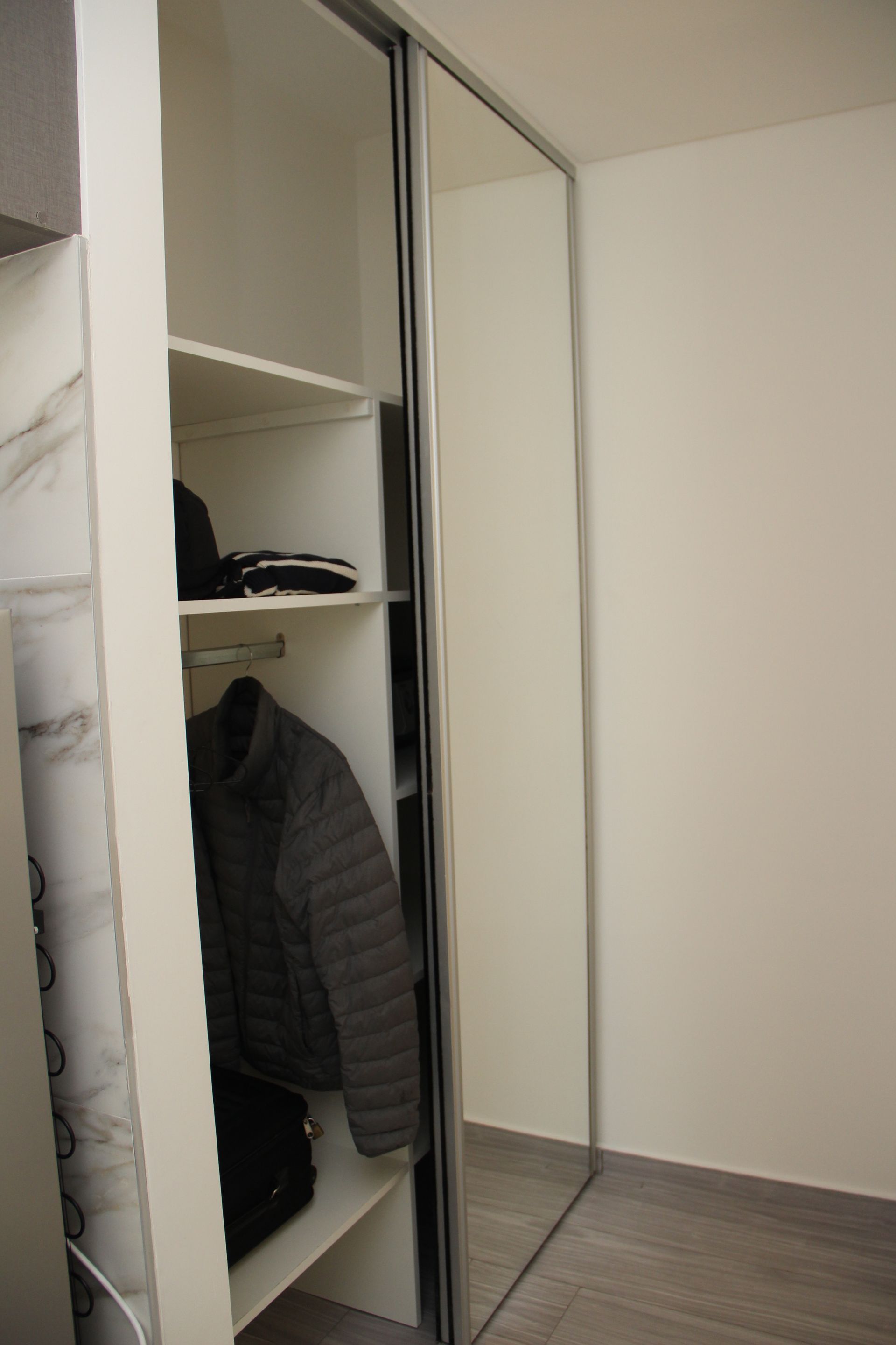 Un armario con puertas corredizas de vidrio y un espejo.