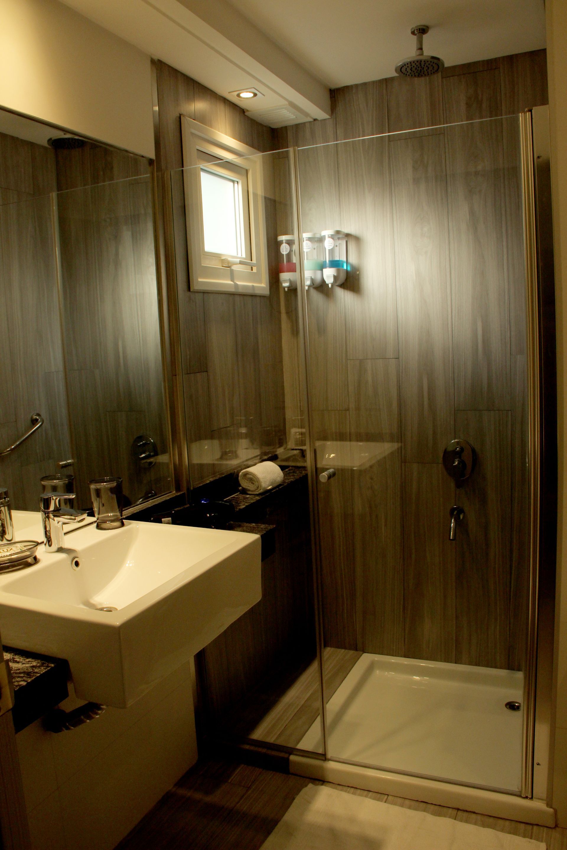 Un baño con lavabo y ducha a ras de suelo.