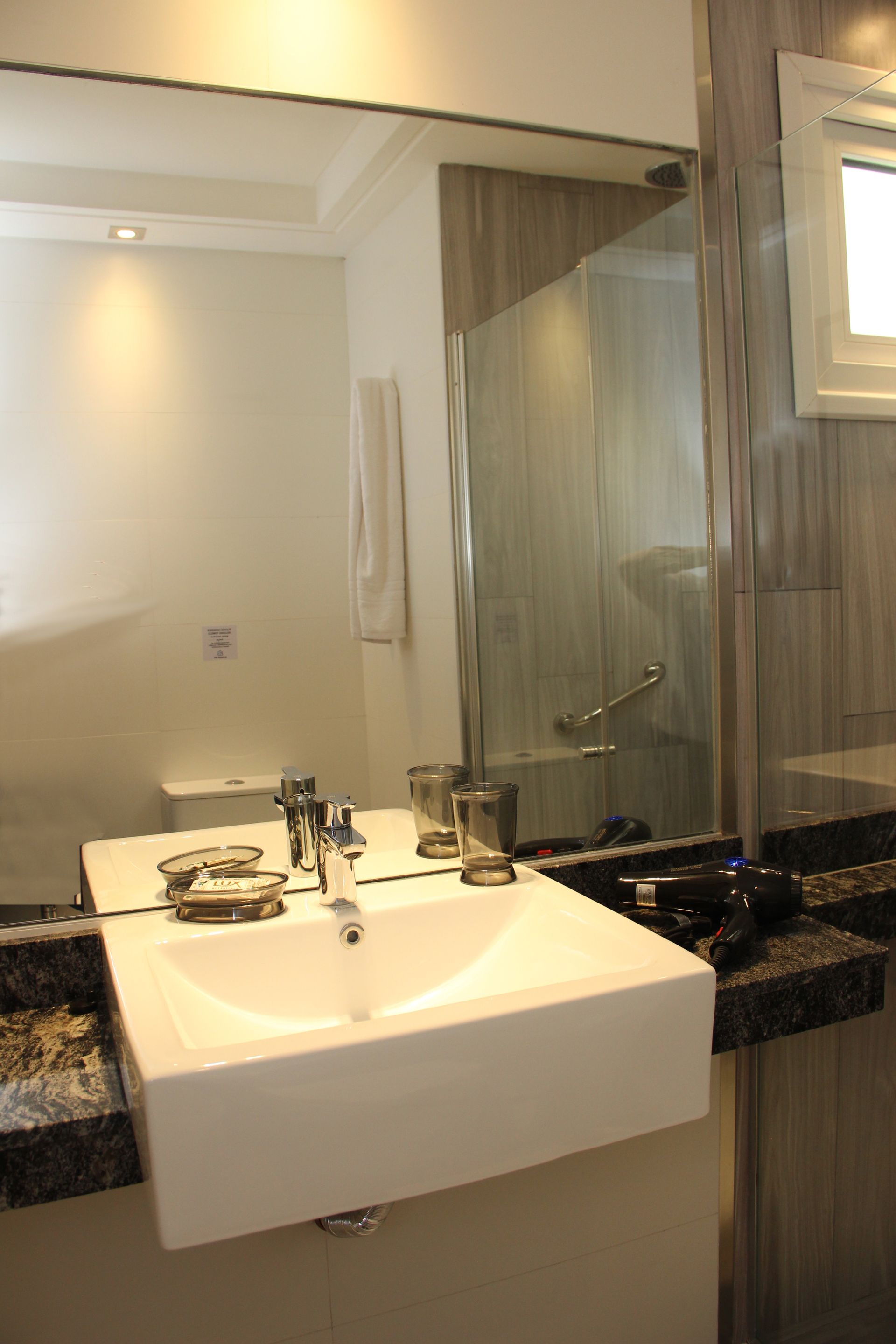 Un baño con lavabo y un espejo grande.