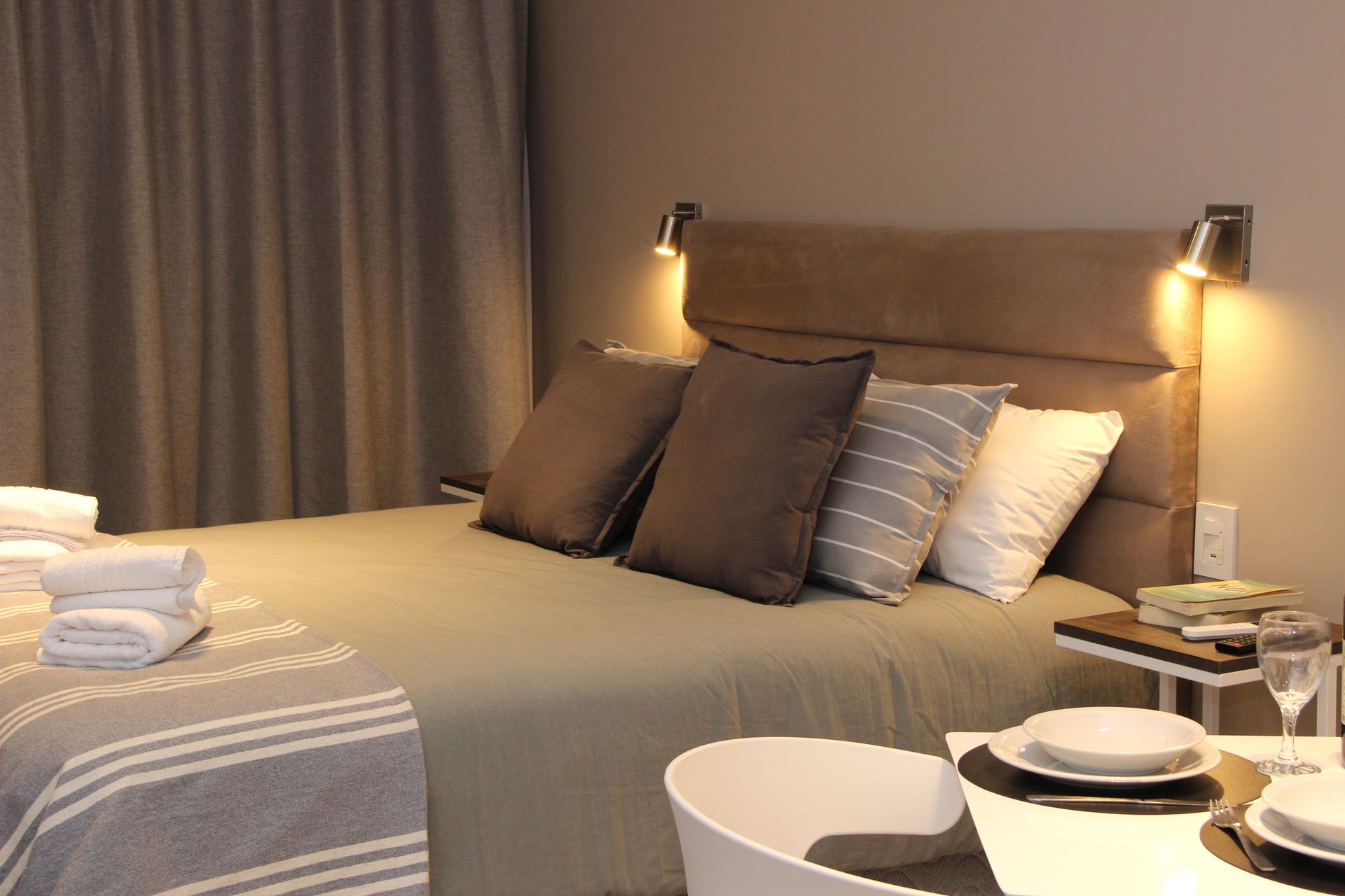 Un dormitorio con una cama y una mesa con platos encima.