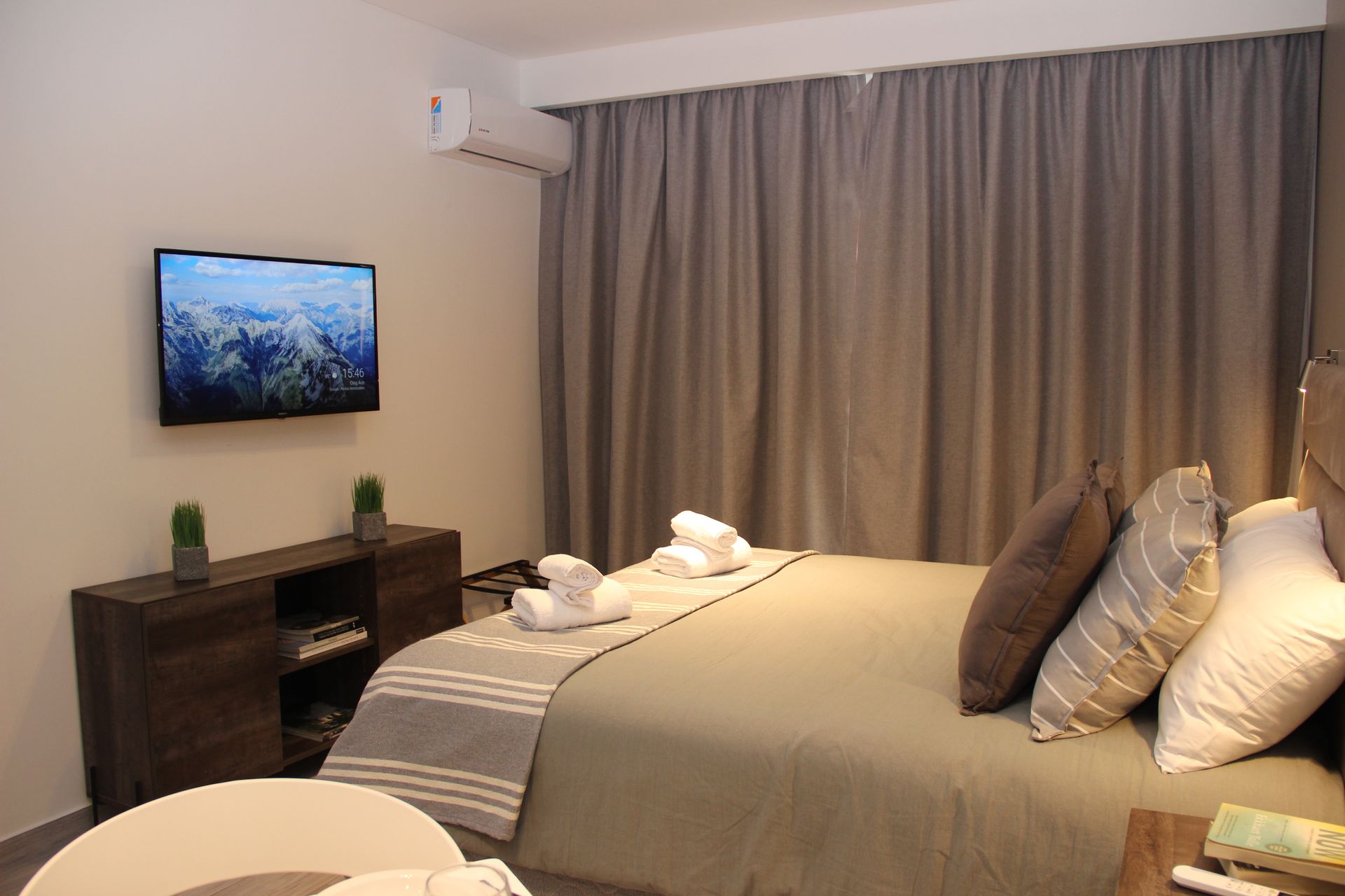 Un dormitorio con una cama, televisión y una mesa.