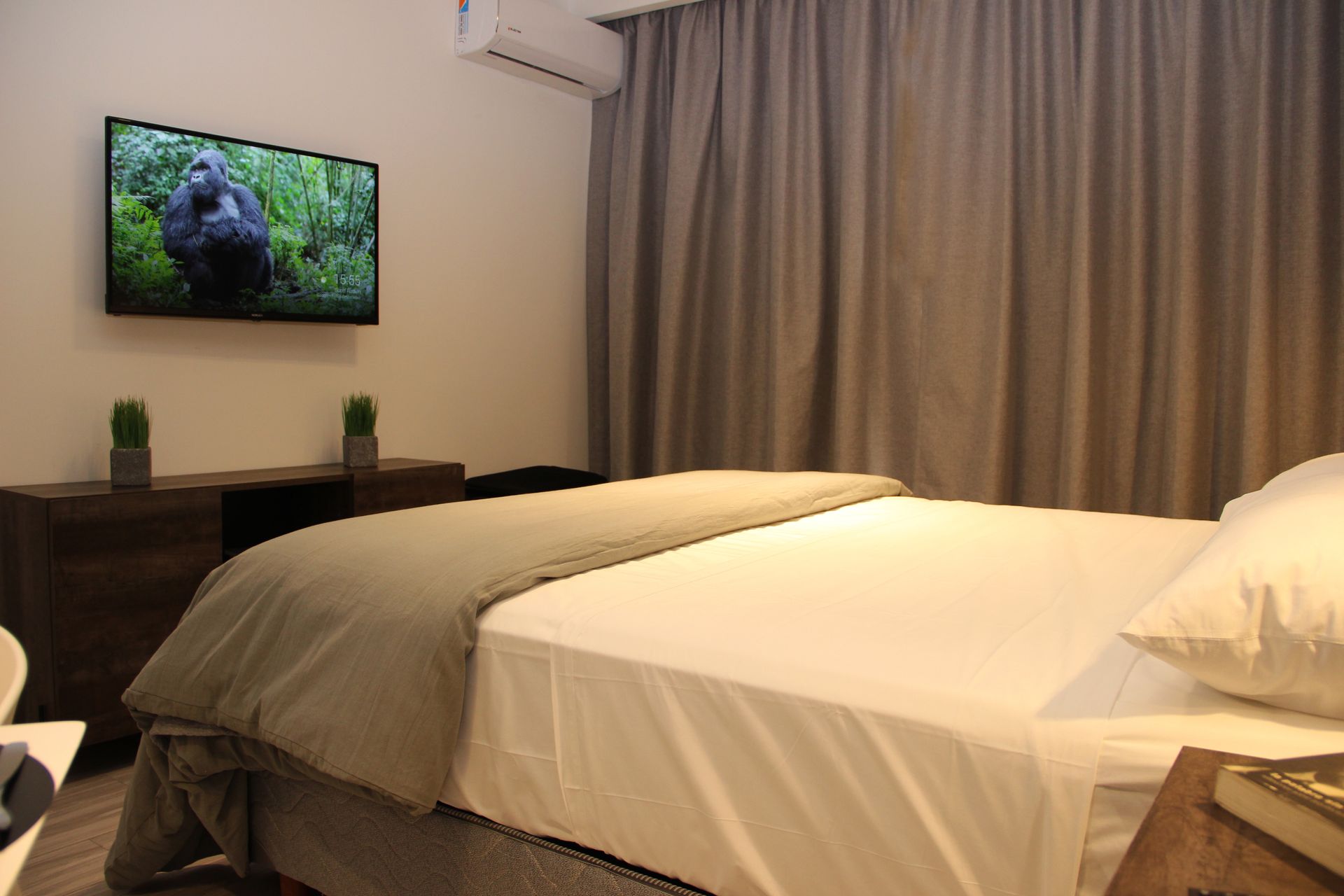 Una habitación de hotel con una cama y un televisor en la pared.