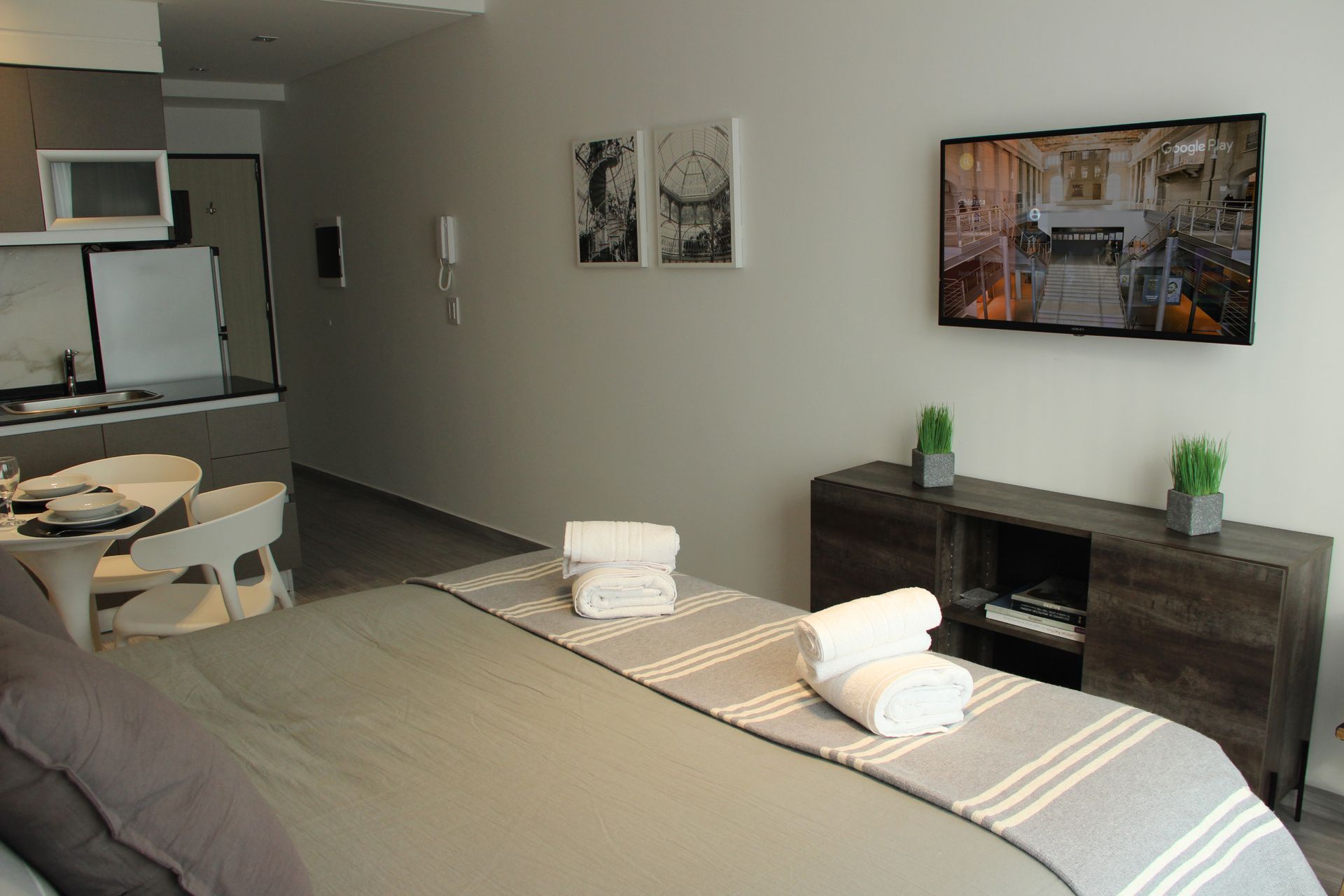 Un dormitorio con una cama grande y un televisor de pantalla plana en la pared.