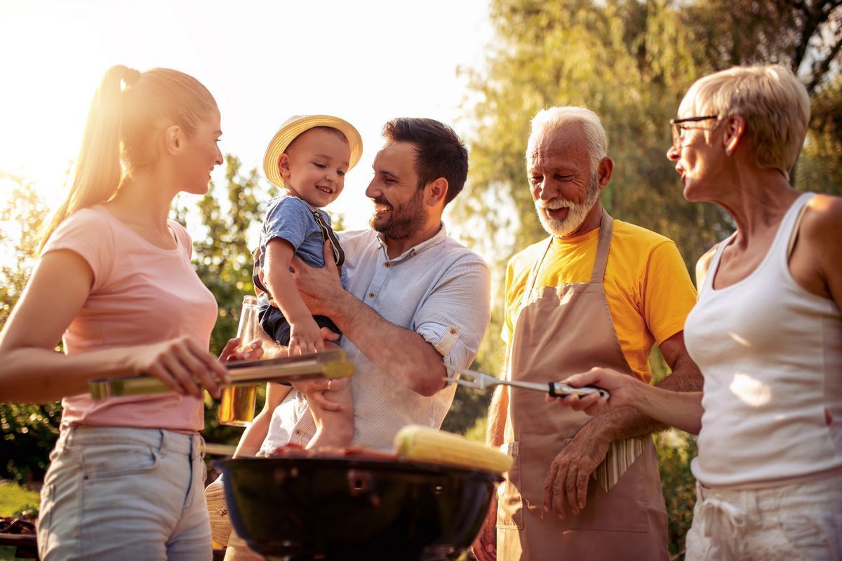 Multi-generational family enjoying a spring barbecue outdoors, showing connection and support.