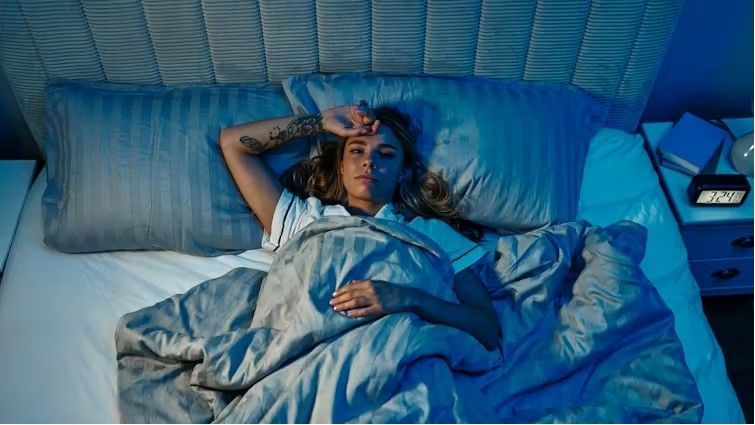 A person lying awake in bed, representing sleep problems and depression support in Albuquerque.