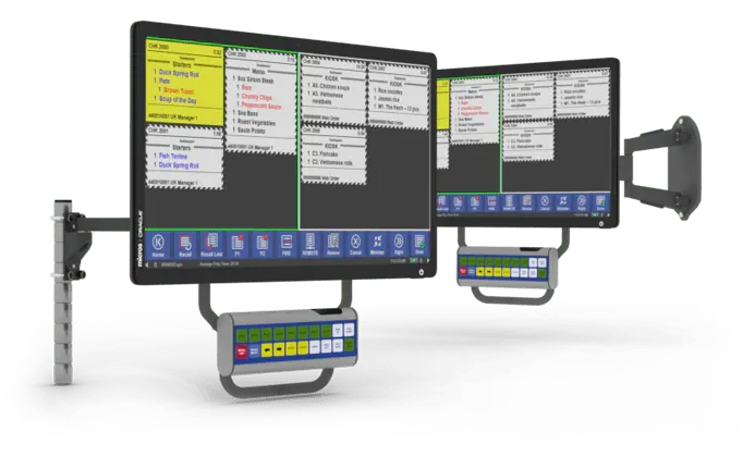 Zwei an der Wand montierte Computerbildschirme mit Zeitplänen und angeschlossenen Bedienfeldern, vermutlich in einer Arztpraxis oder einem Büro.