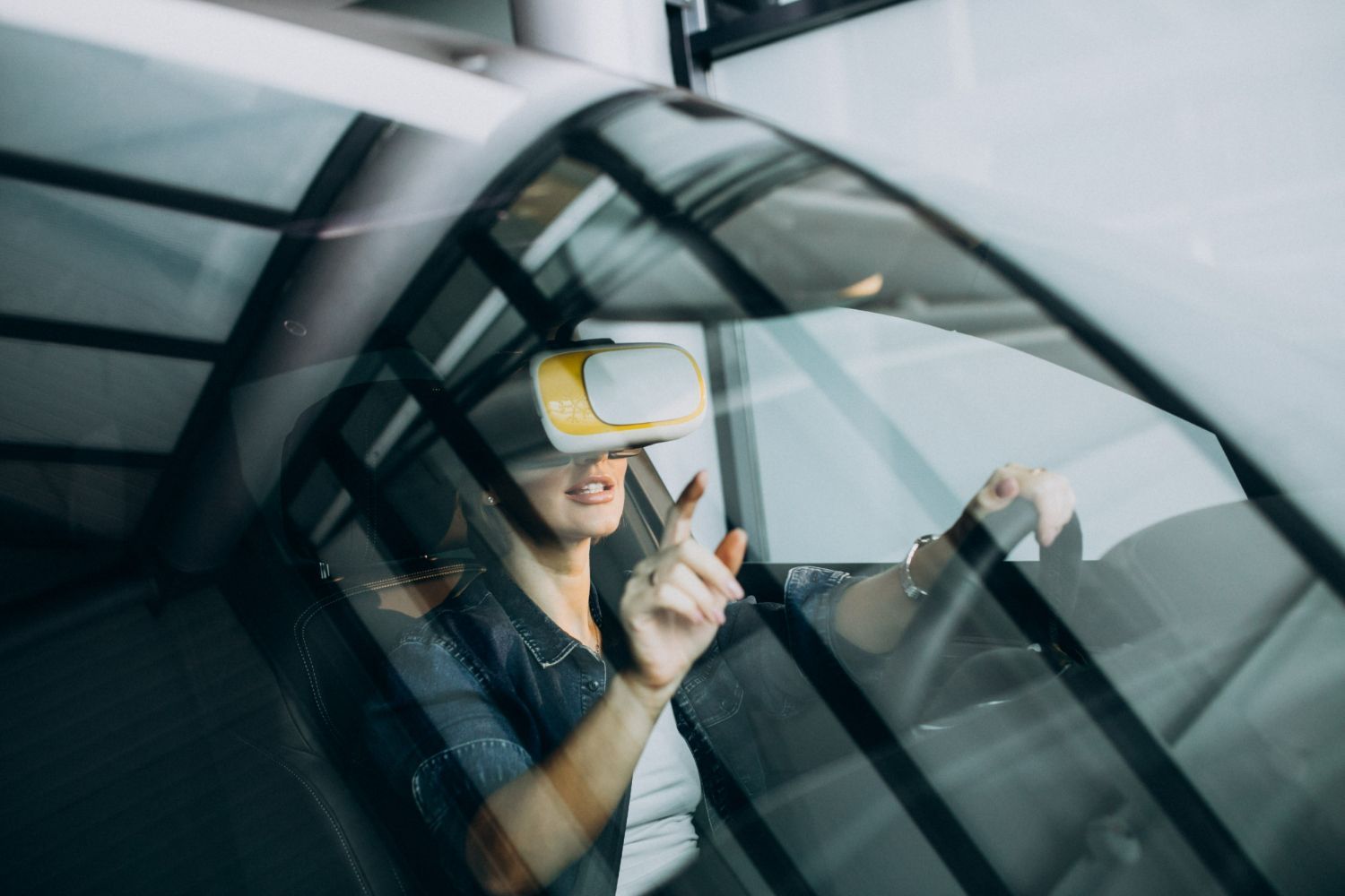 Woman wearing VR headset in car, gesturing with hand.