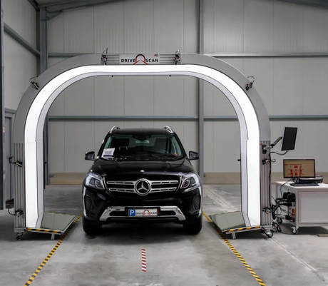 A black mercedes is being checked by a machine