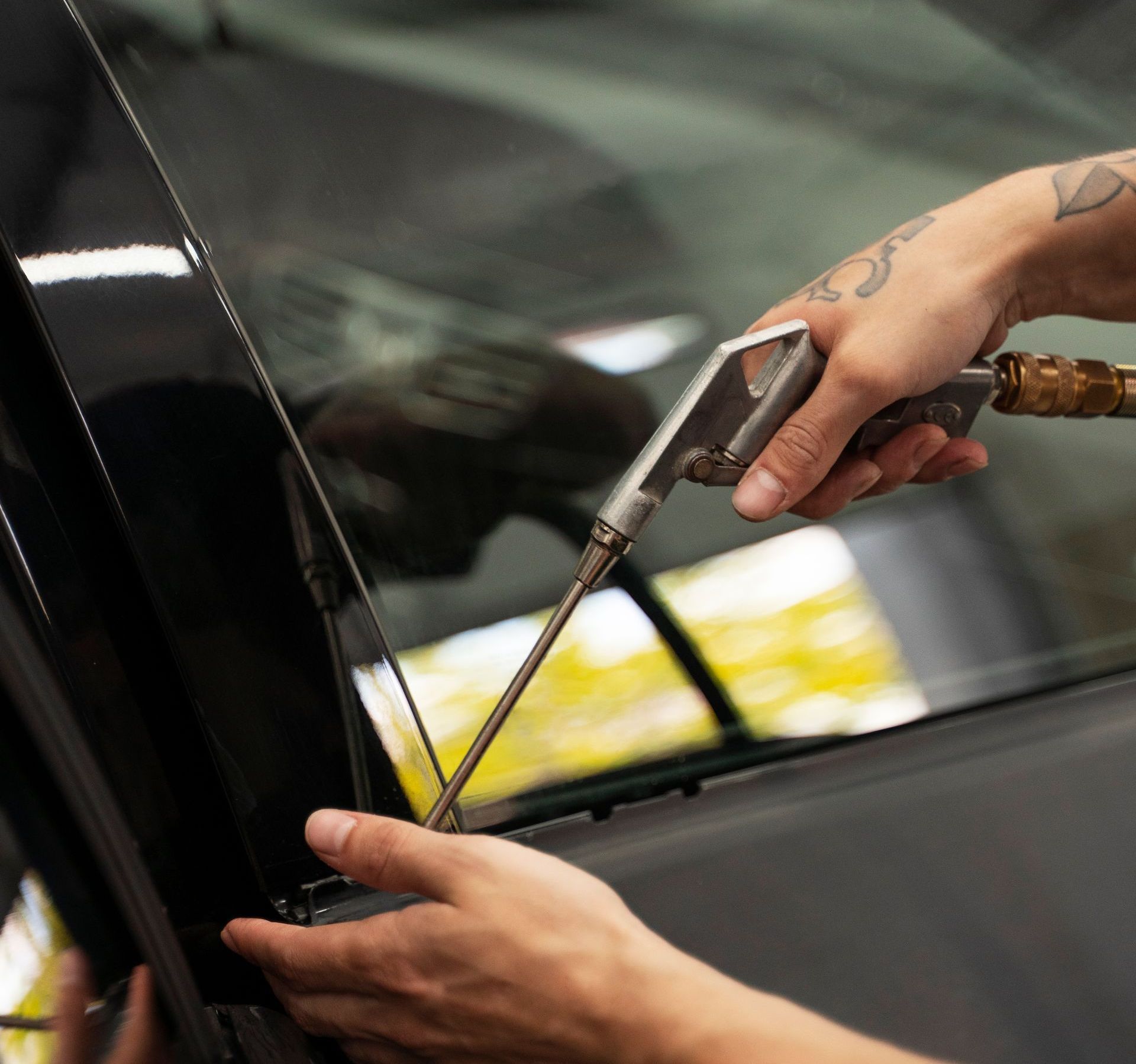 A person is blowing air into a car window