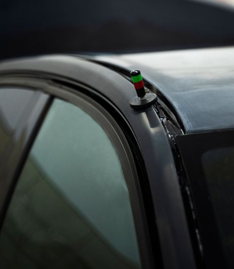 A close up of a car with a green red and white antenna