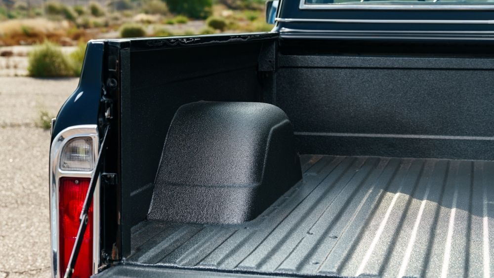 Black truck bed interior with textured liner and wheel well.